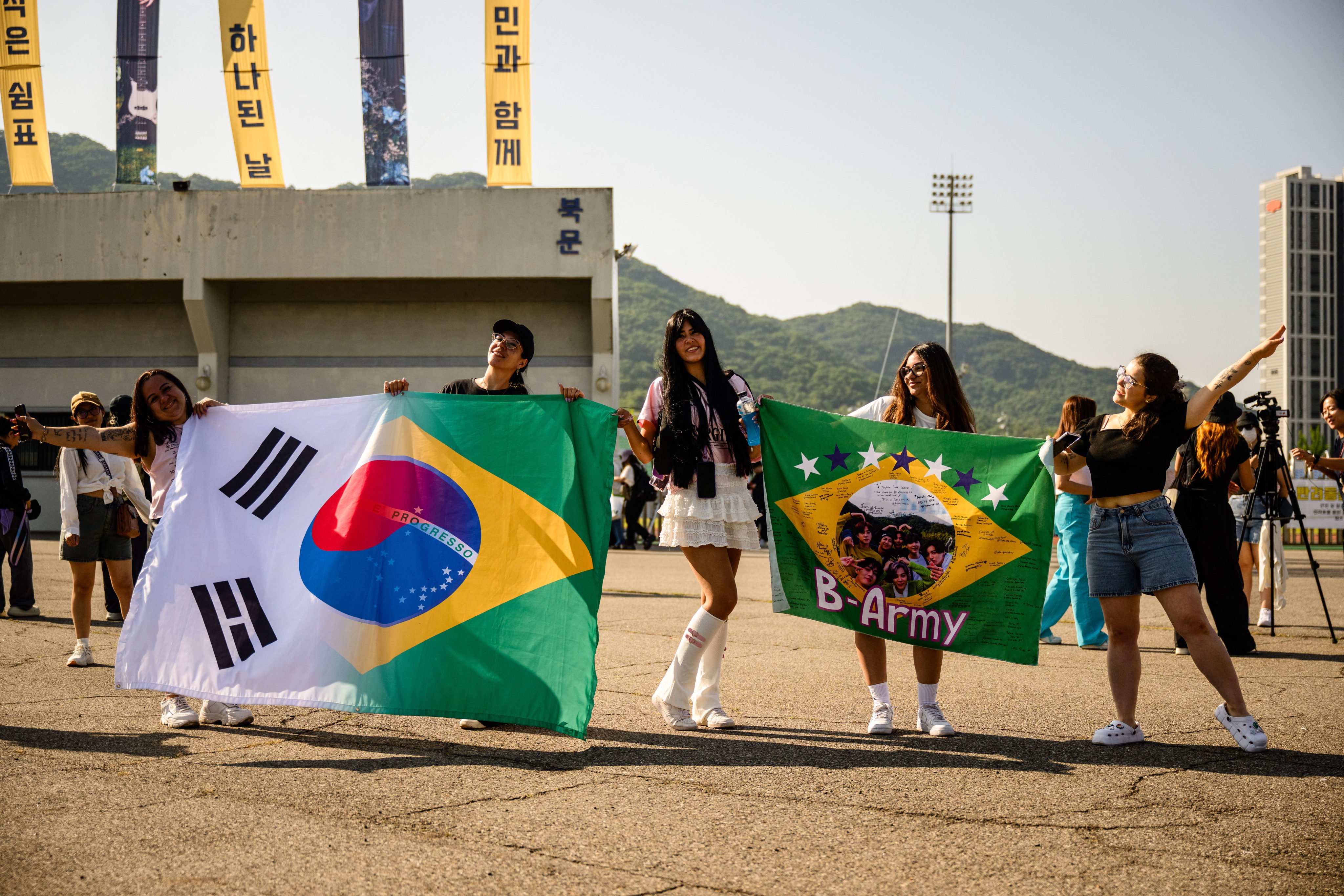 BTS fans who flew from Brazil to see the K-pop super act’s members Jungkook and Jimin released from military service pose with flags in Yeoncheon, South Korea, on June 11 last year. Photo: AFP