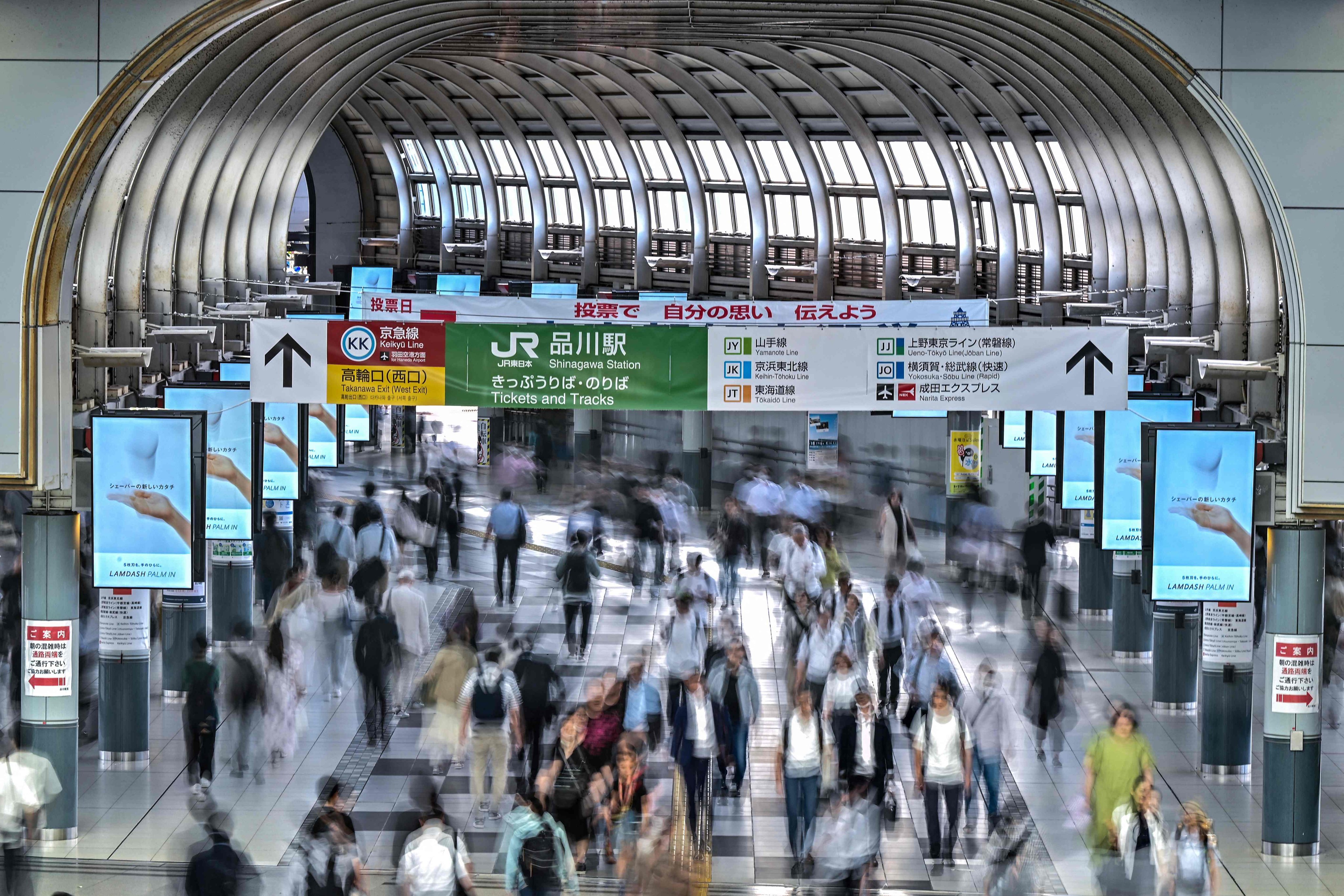 Passengers walk through Shinagawa Station in Tokyo. The average Japanese worker put in 1,654.2 hours over the 2024 financial year. Photo: AFP