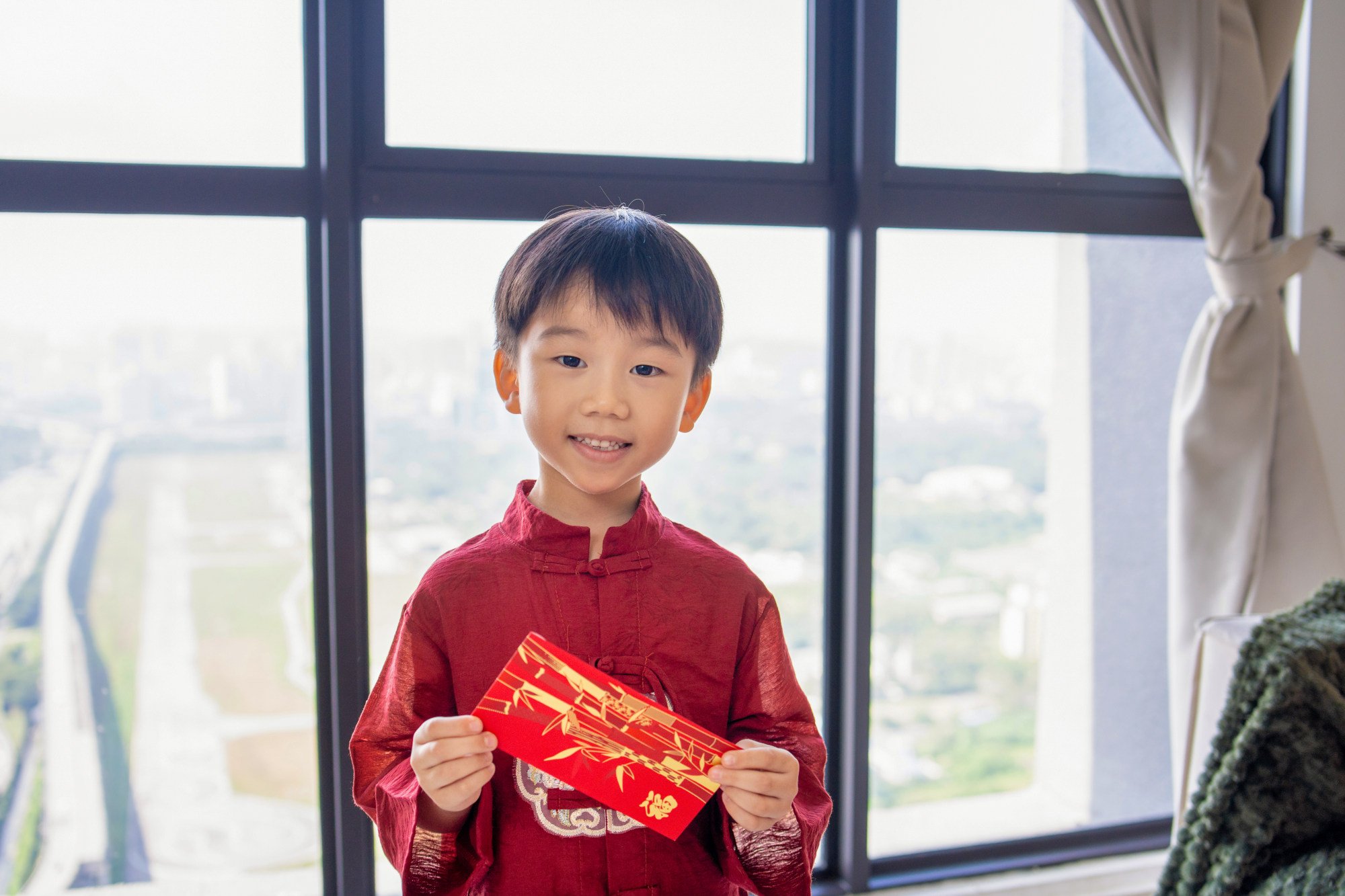 A little boy in traditional attire holds a lucky red envelope gift at home. Photo: Getty Images A little boy in traditional attire holds a lucky red envelope gift at home. Photo: Getty Images