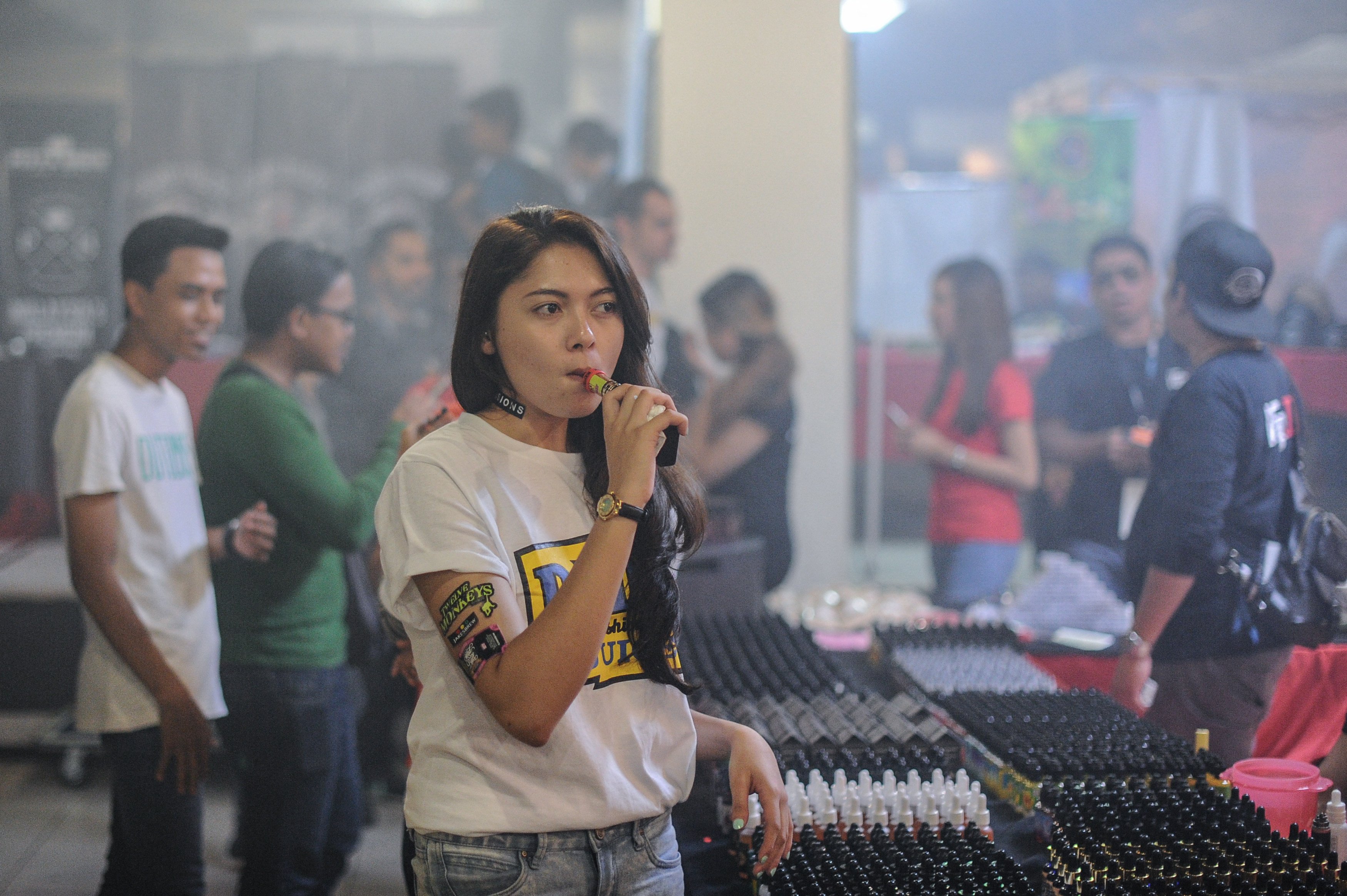 A promoter smokes an electronic cigarette during the VapeFair in Kuala Lumpur in December 2015. Malaysian officials have discussed a full national ban on refillable vapes by mid-2026. Photo: AFP