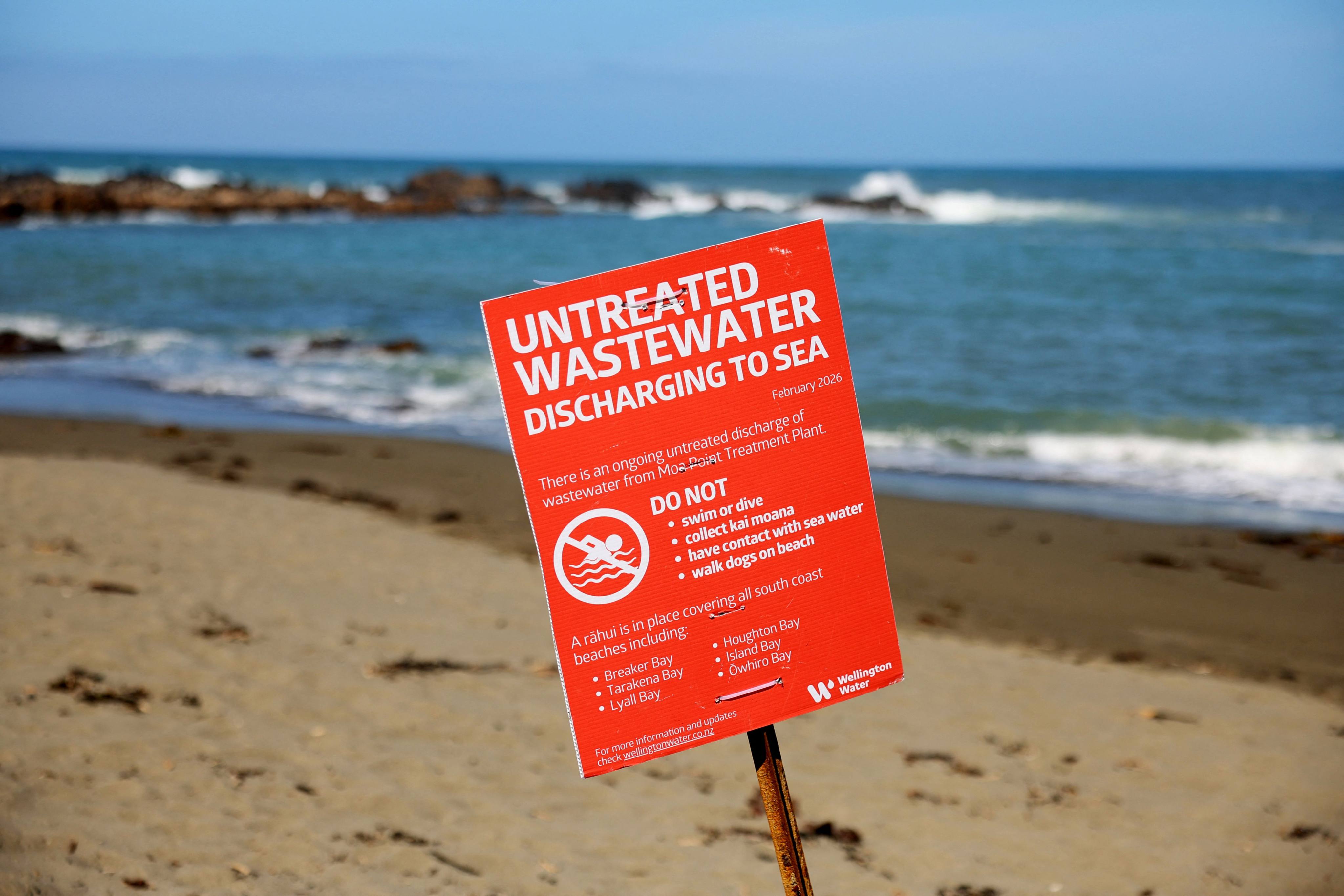 A warning sign is seen on Wellingtons South Coast on Monday after millions of litres of untreated sewage were discharged into the ocean. Photo: AFP
