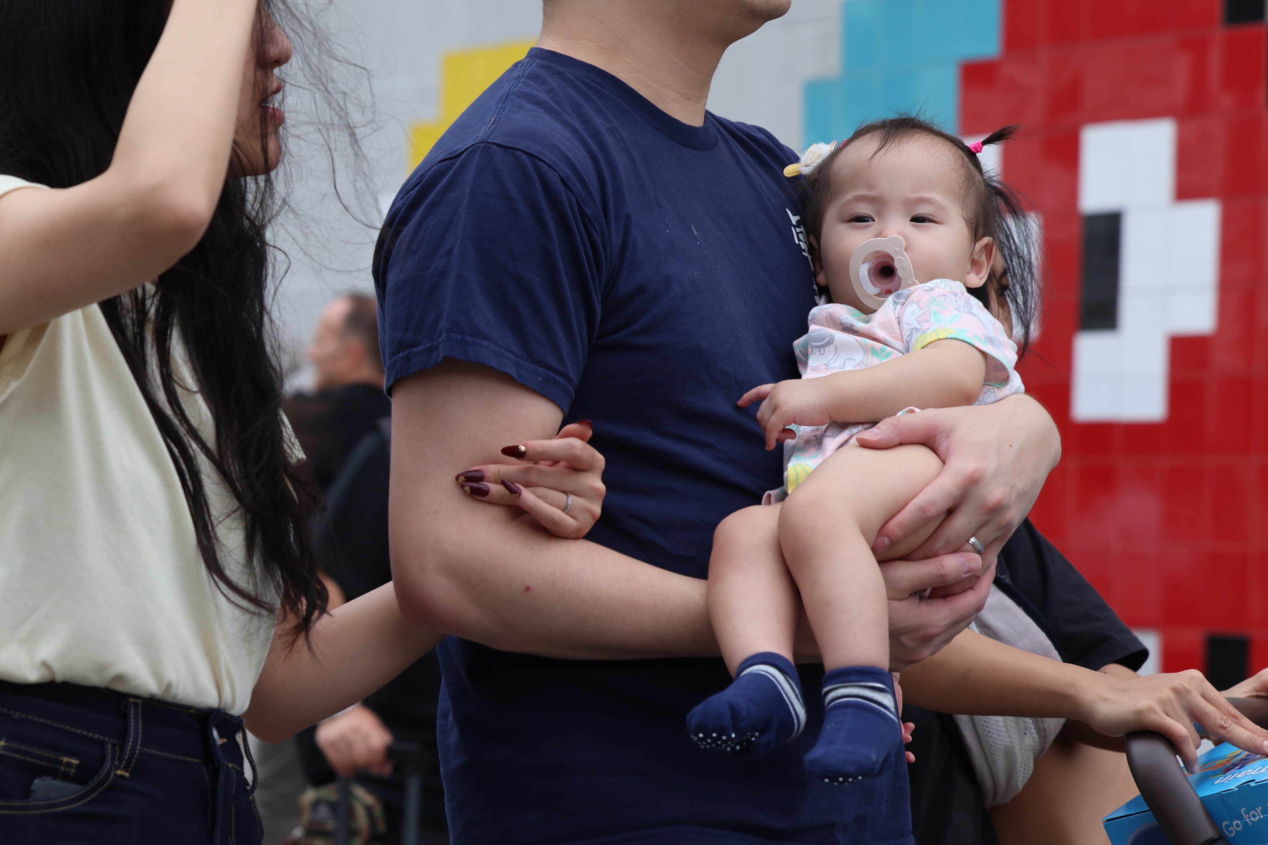 A man with a baby passes by the Tsim Sha Tsui waterfront. The majority of Hong Kong residents are not choosing to have children, according to the latest figures. Photo: Jelly Tse