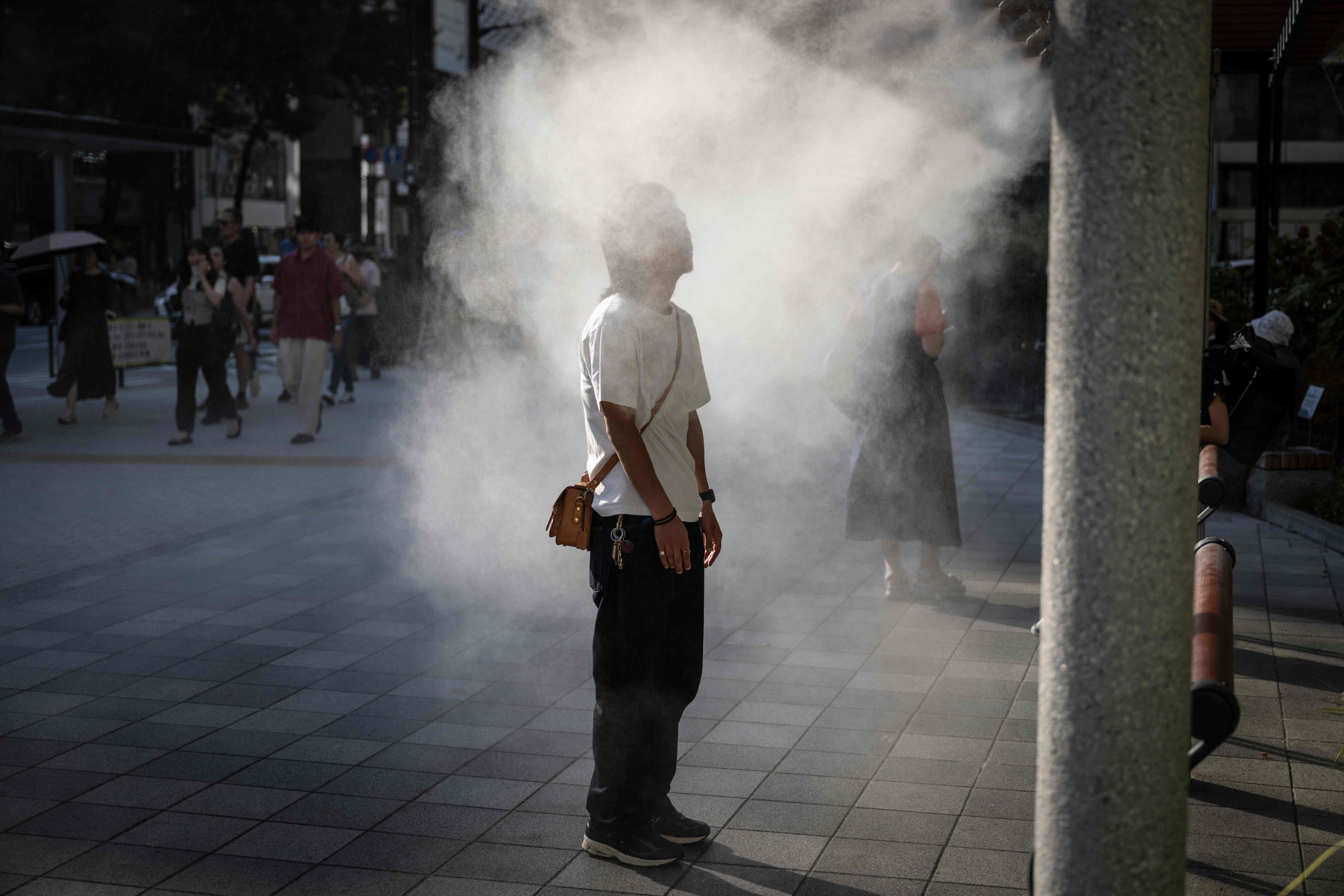 A man cooling down under a water misting system on a hot day in Tokyo in September last year. Photo: AFP