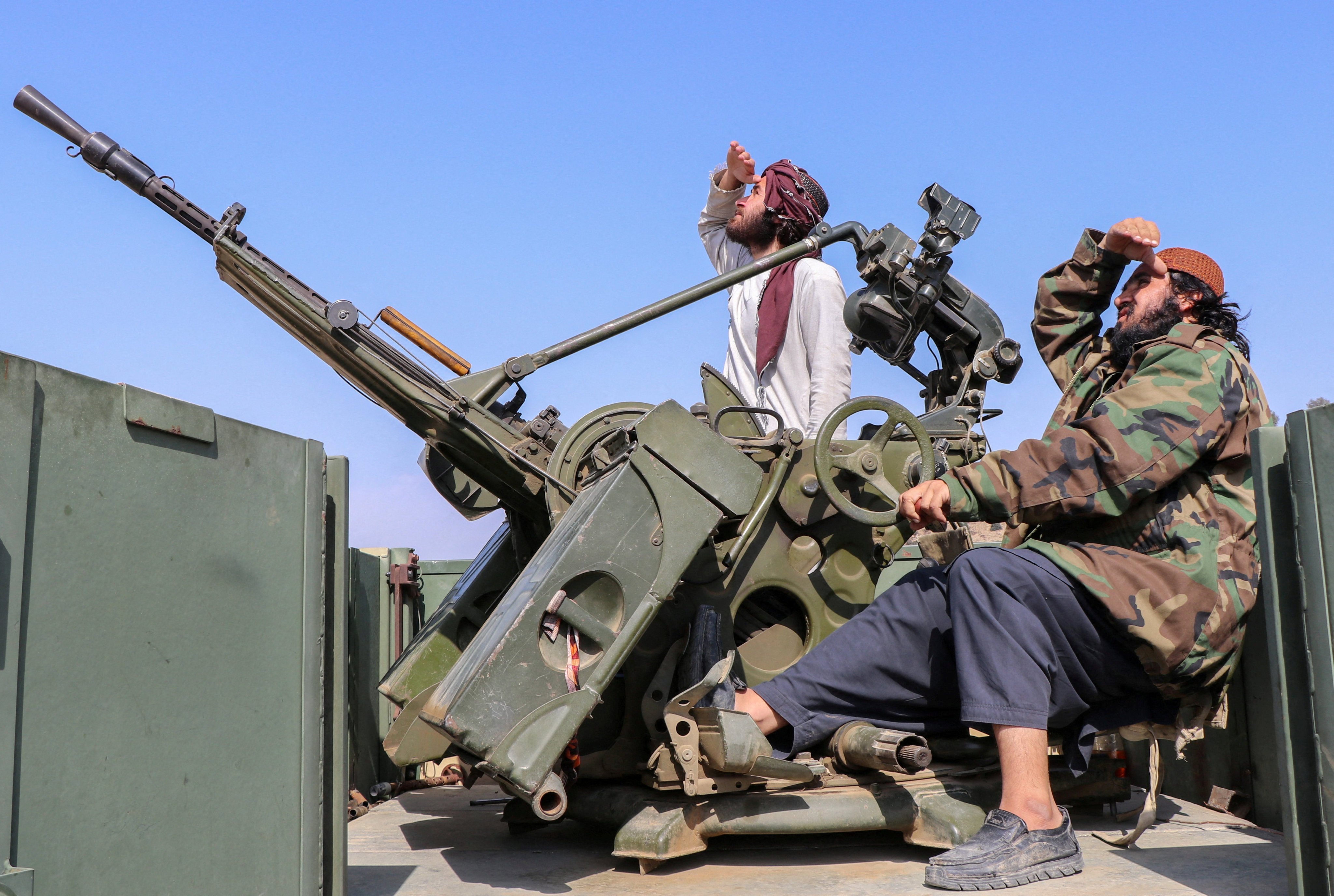 Taliban soldiers sit next to an anti-aircraft gun while on lookout for Pakistan’s fighter jets in Afghanistan’s Khost province on Friday. Photo: Reuters