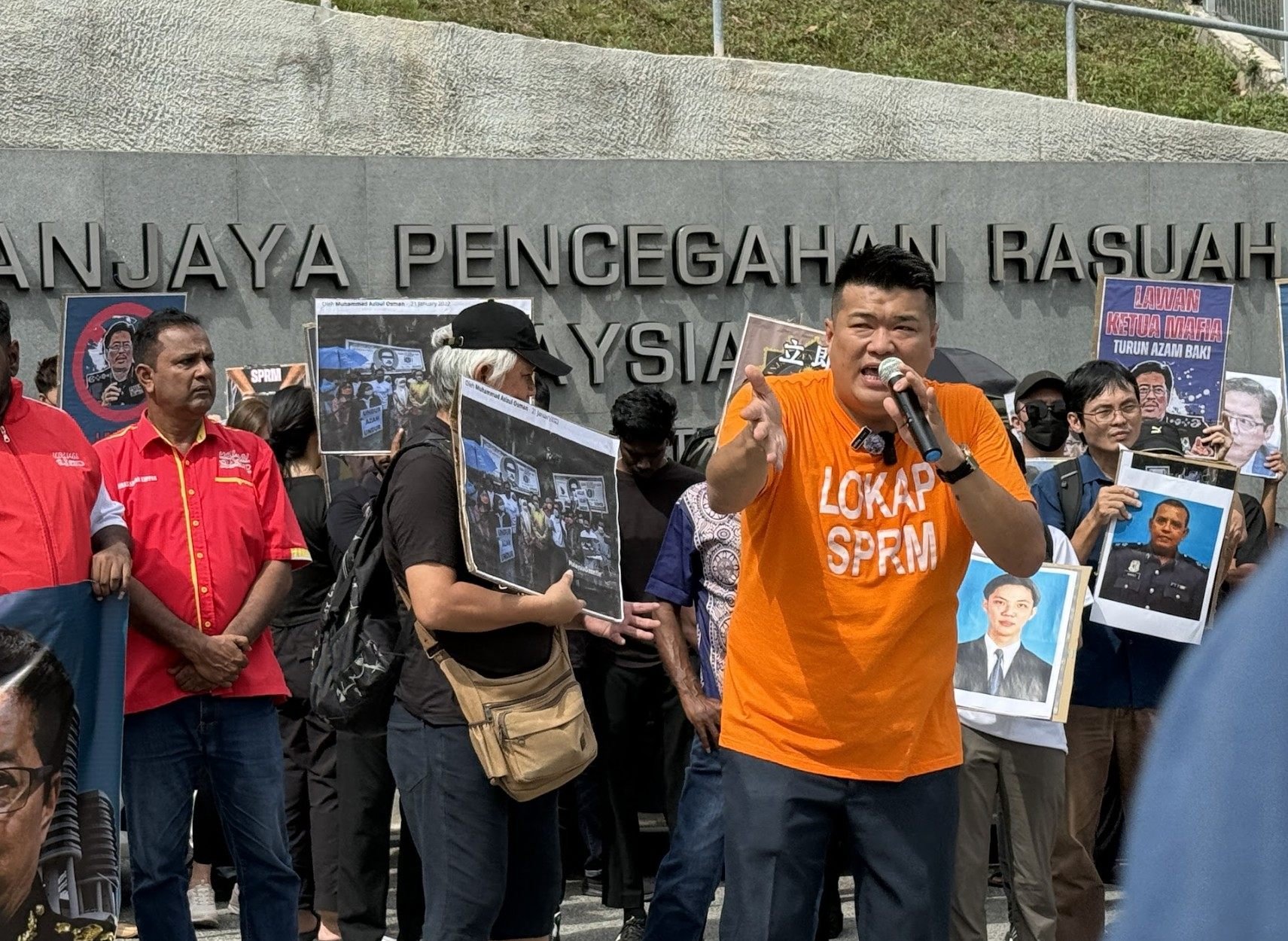 Rally organiser Albert Tei, clad in an orange MACC lock-up T-shirt, speaks in front of the anti-graft agency’s headquarters in Putrajaya on Friday. Photo: Iman Muttaqin