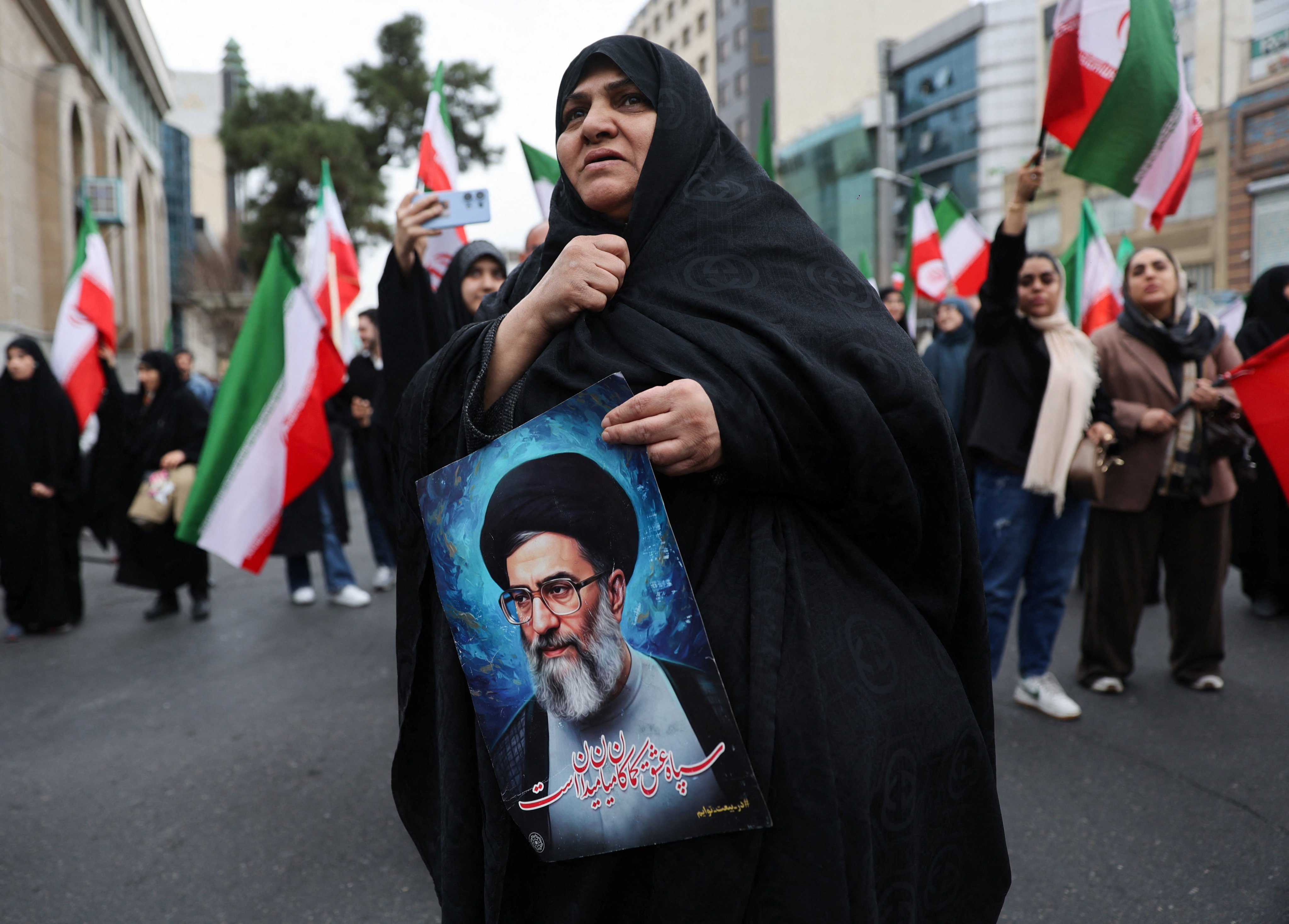 A woman holds an image of Iran’s Supreme Leader Ayatollah Ali Khamenei as Iranian demonstrators protest against the U.S.-Israeli strikes, in Tehran, Iran on February 28, 2026. Photo: Reuters