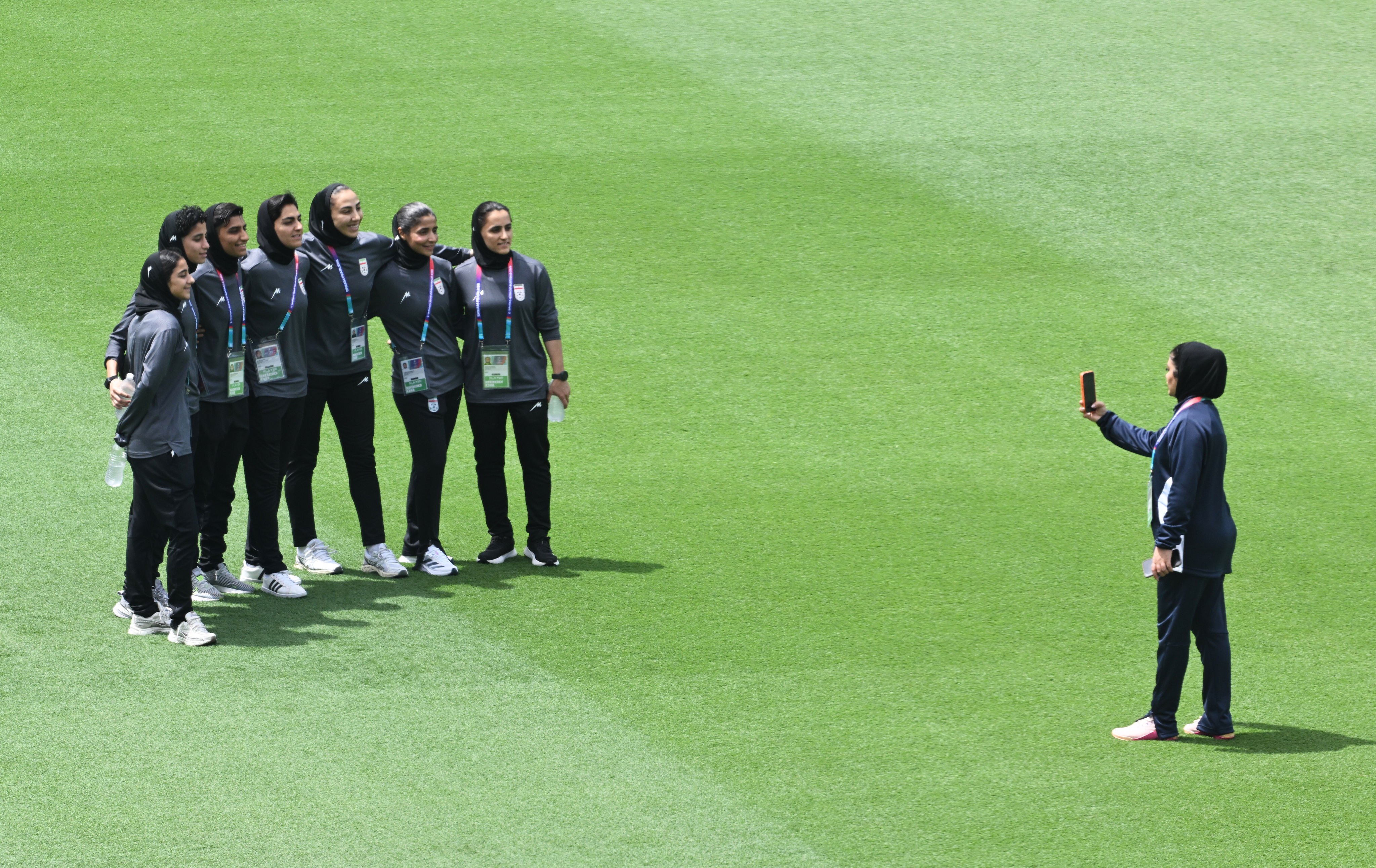 Members of the Iranian women’s team pose for photographs after inspecting the pitch ahead of their game against South Korea at Robina Stadium on the Gold Coast. Photo: AP