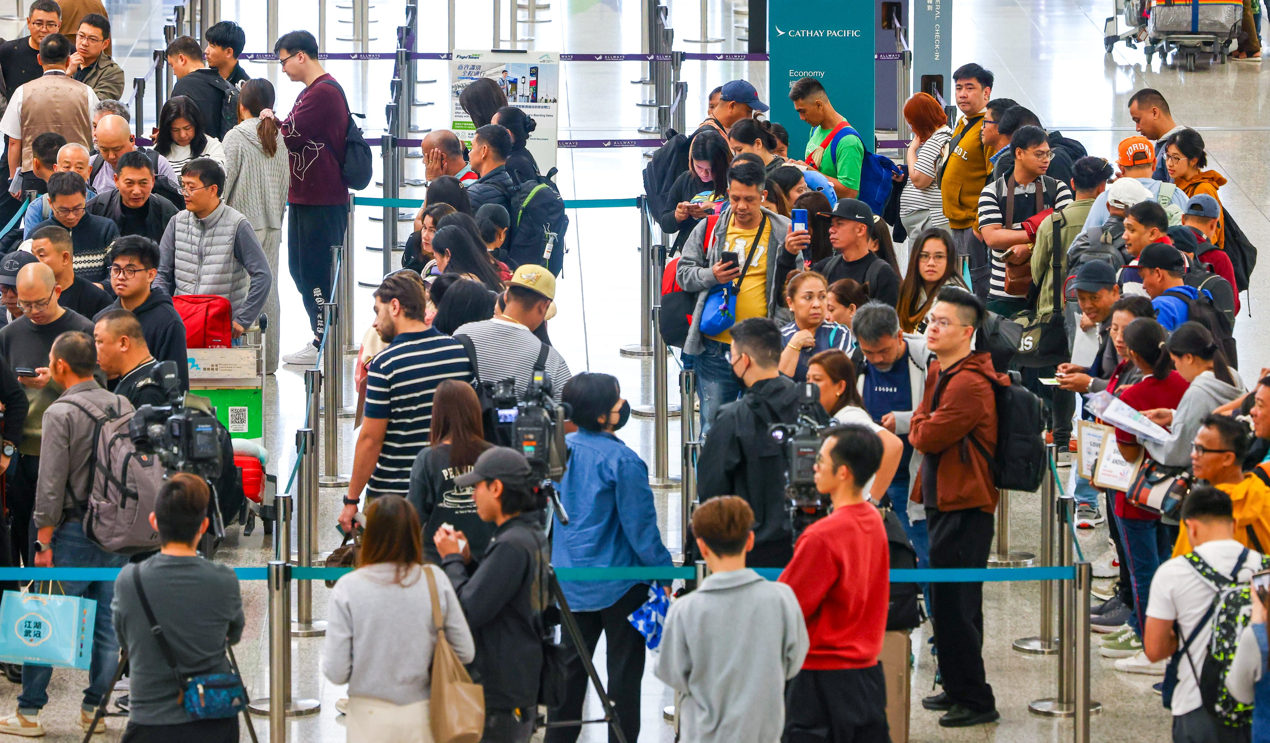 Passengers affected by disruptions to Cathay Pacific flights to Riyadh and Dubai queue to make inquiries at the airline’s check-in counters at Hong Kong International Airport on Saturday. Photo: Dickson Lee