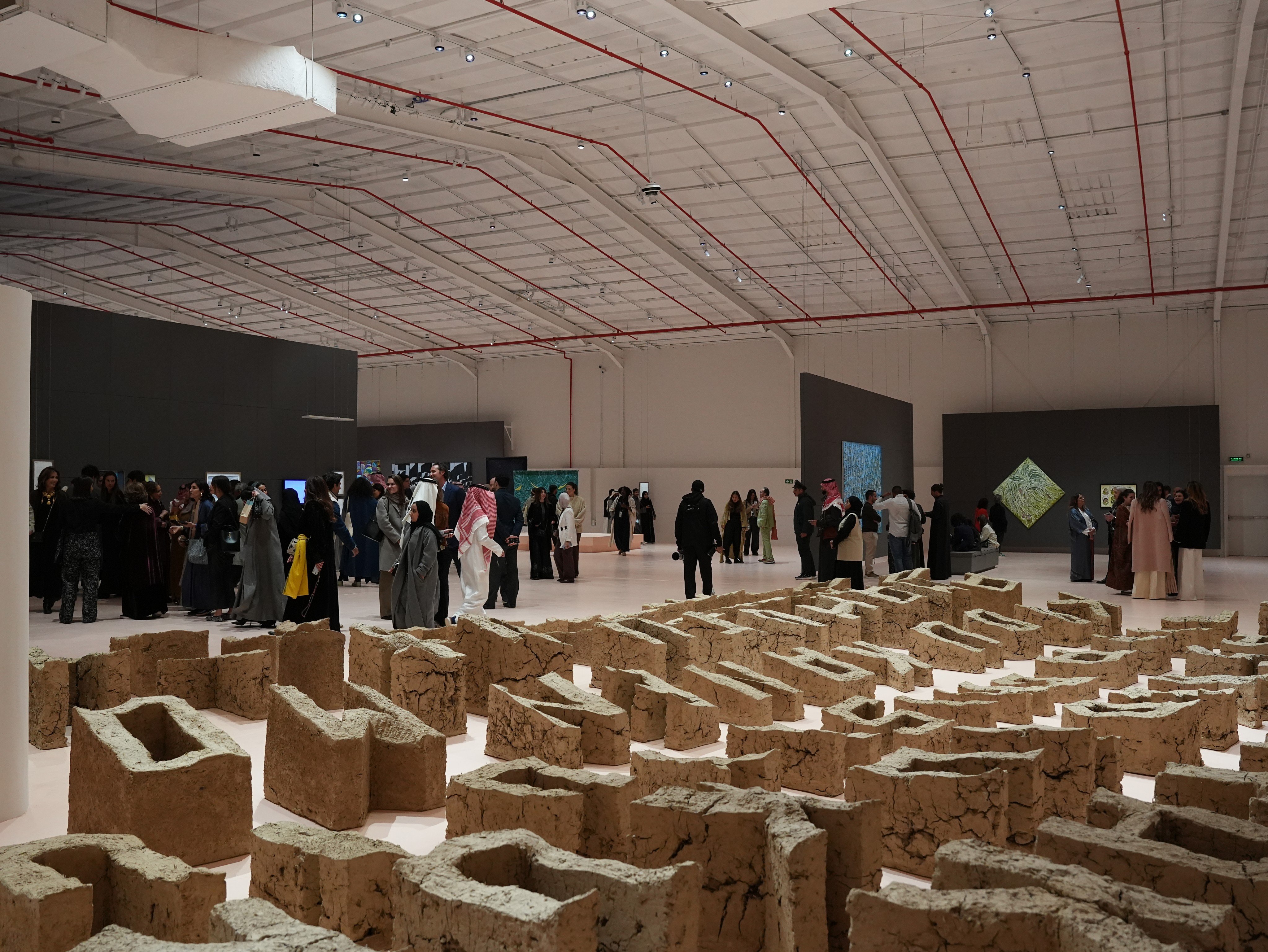 Visitors to the Diriyah Contemporary Art Biennale 2026 walk beside British-Filipino artist Pio Abad’s “Vanwa”, consisting of 99 letters made from locally sourced mud. Photo: courtesy of the Diriyah Biennale Foundation