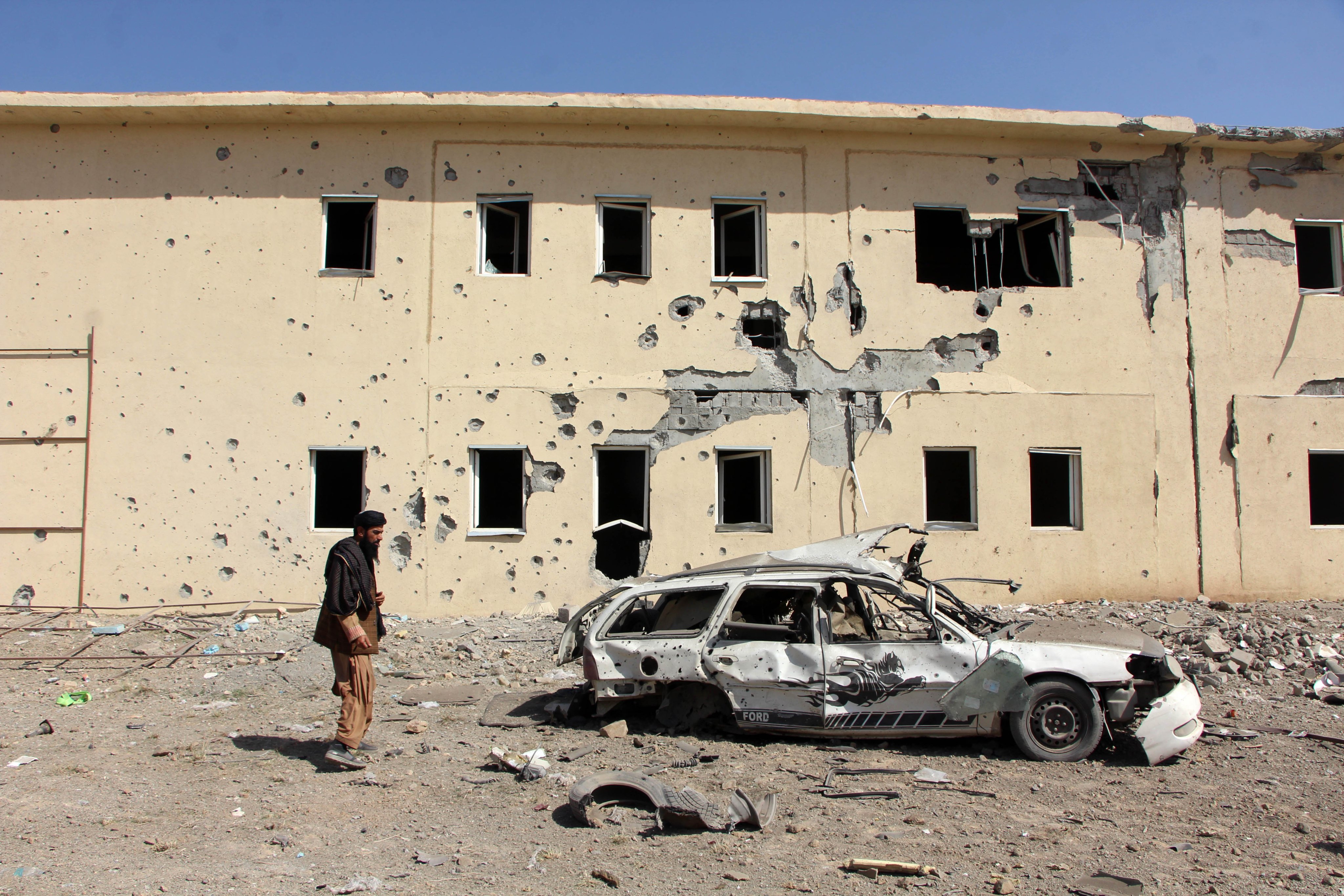 People survey a house that was damaged in the cross-border clashes between Pakistan and Afghanistan, in the Takhta-e-Pul district of Kandahar province, Afghanistan, on February 28. Photo: EPA