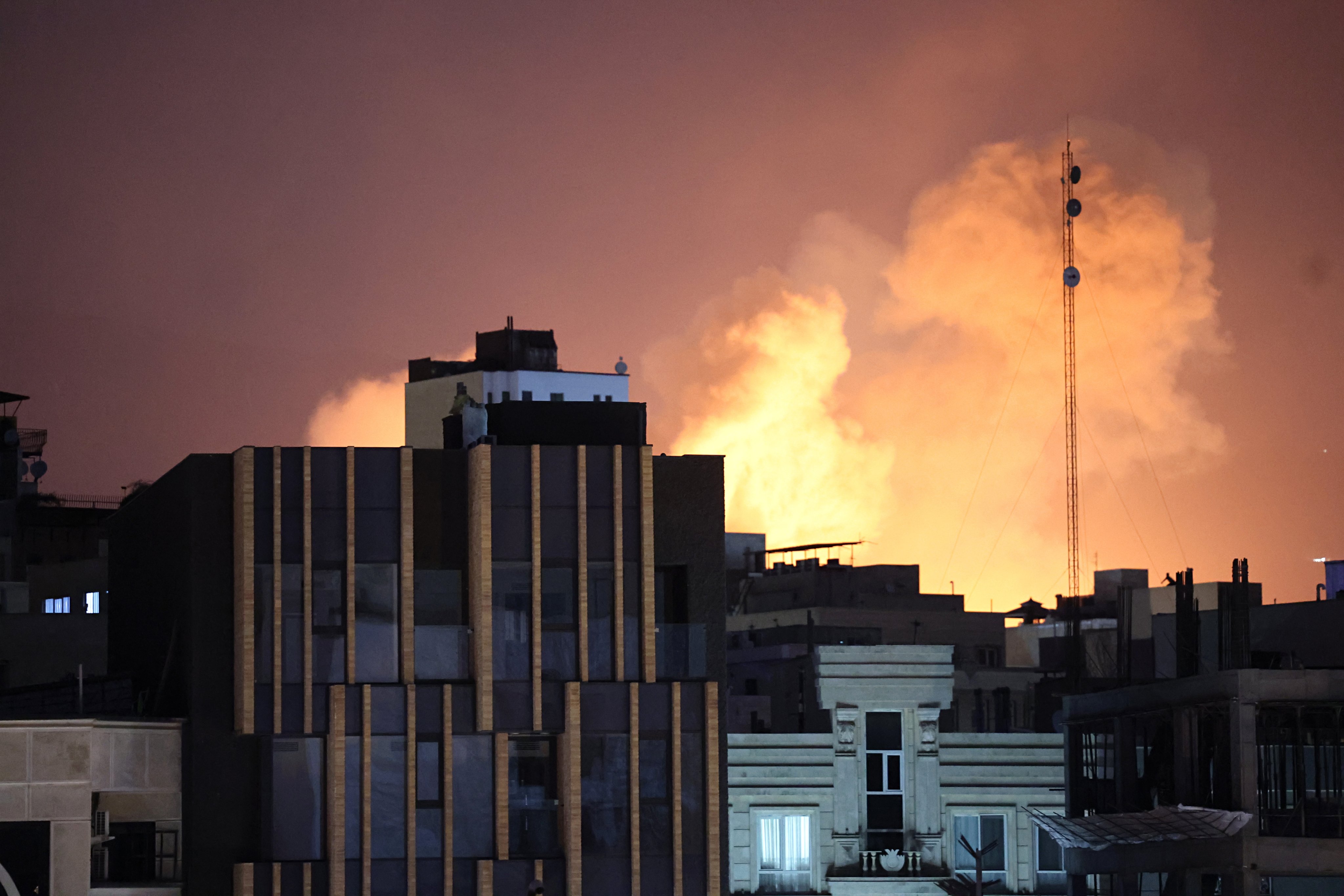 Flames rise behind  buildings in Tehran.  Photo: EPA