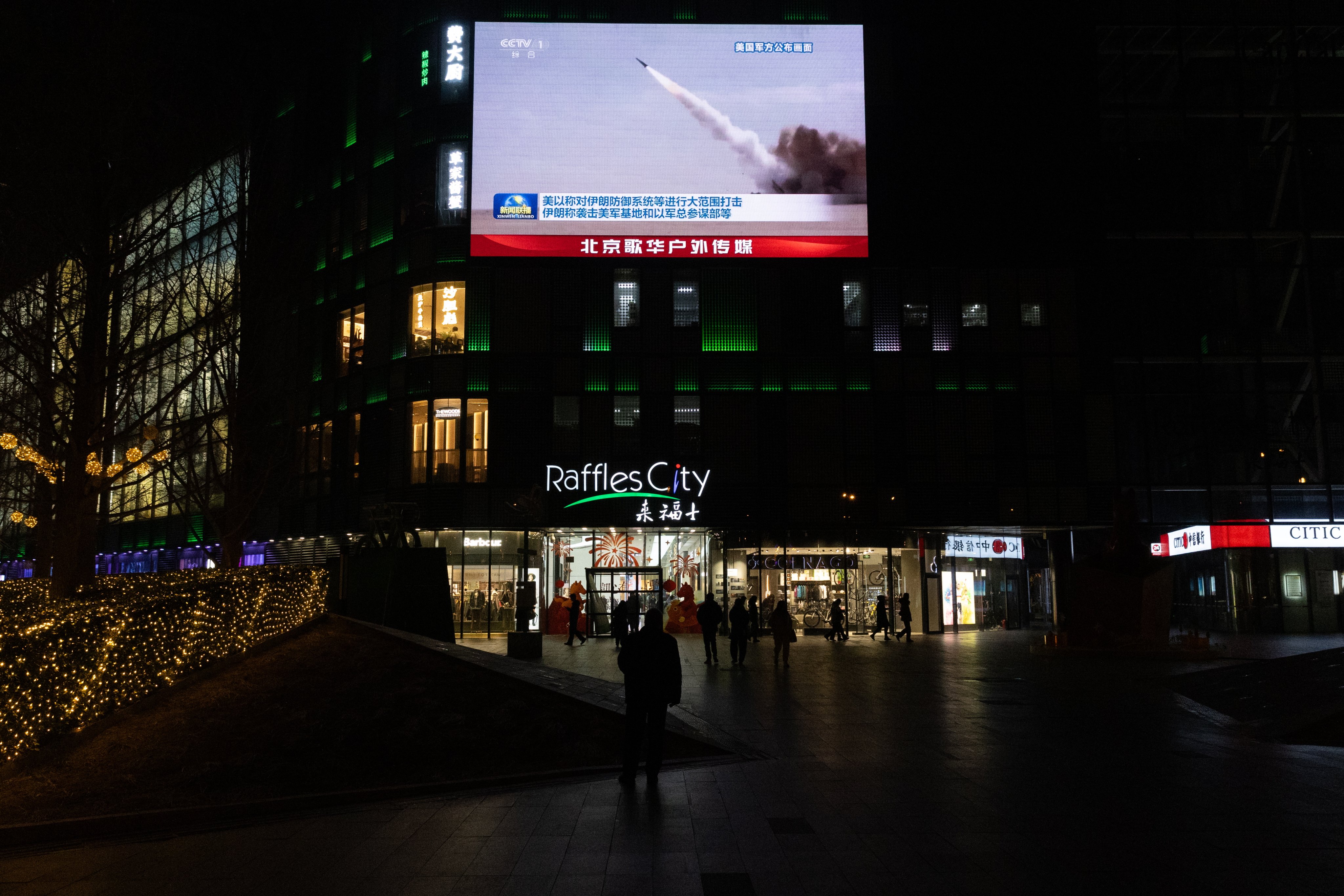 Beijing shoppers watch coverage of US-Israeli air strikes in Iran. Photo: EPA