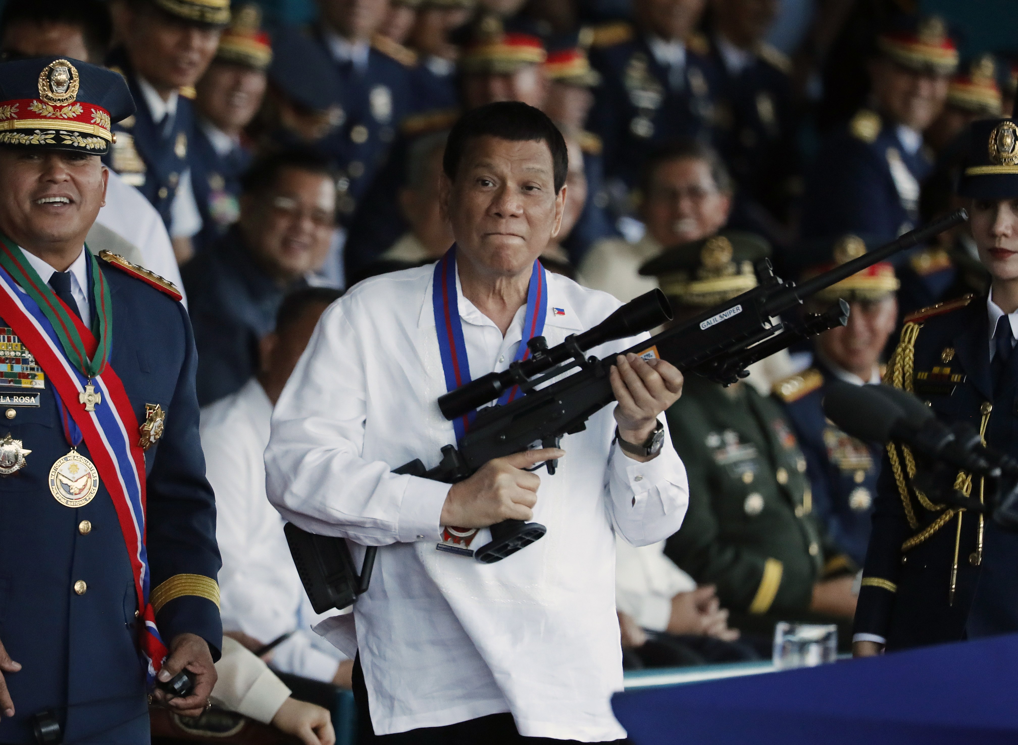 Philippine President Rodrigo Duterte (centre) holds a Galil sniper rifle during the national police chief change of command ceremony inside Camp Crame in Quezon City in April 2018. Duterte is accused of overseeing a campaign of extrajudicial killings linked to his signature “war on drugs”. Photo: EPA-EFE