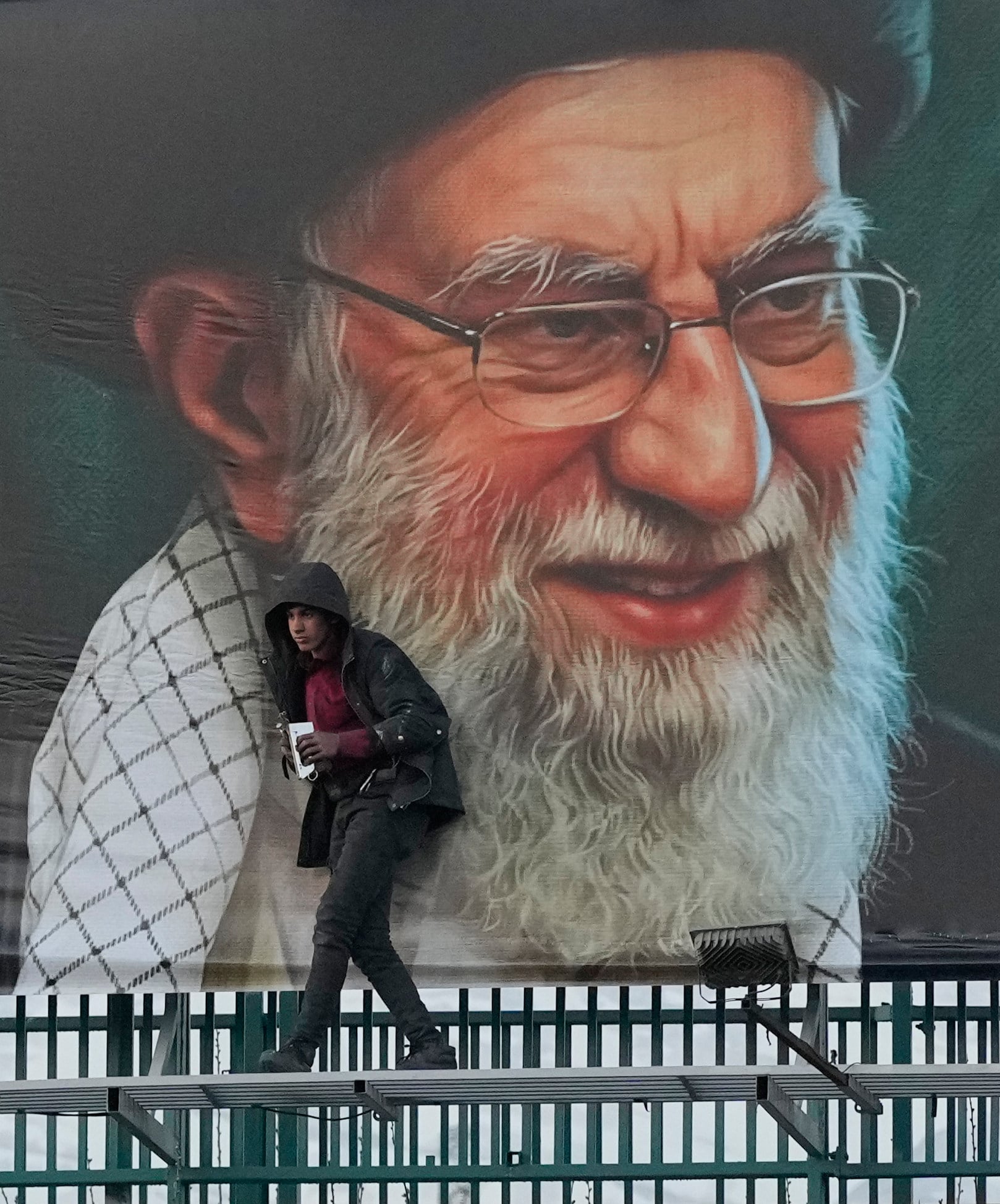 A worker installs a billboard on a Tehran overpass containing a portrait of the late Iranian Supreme leader Ayatollah Ali Khamenei. Photo: AP