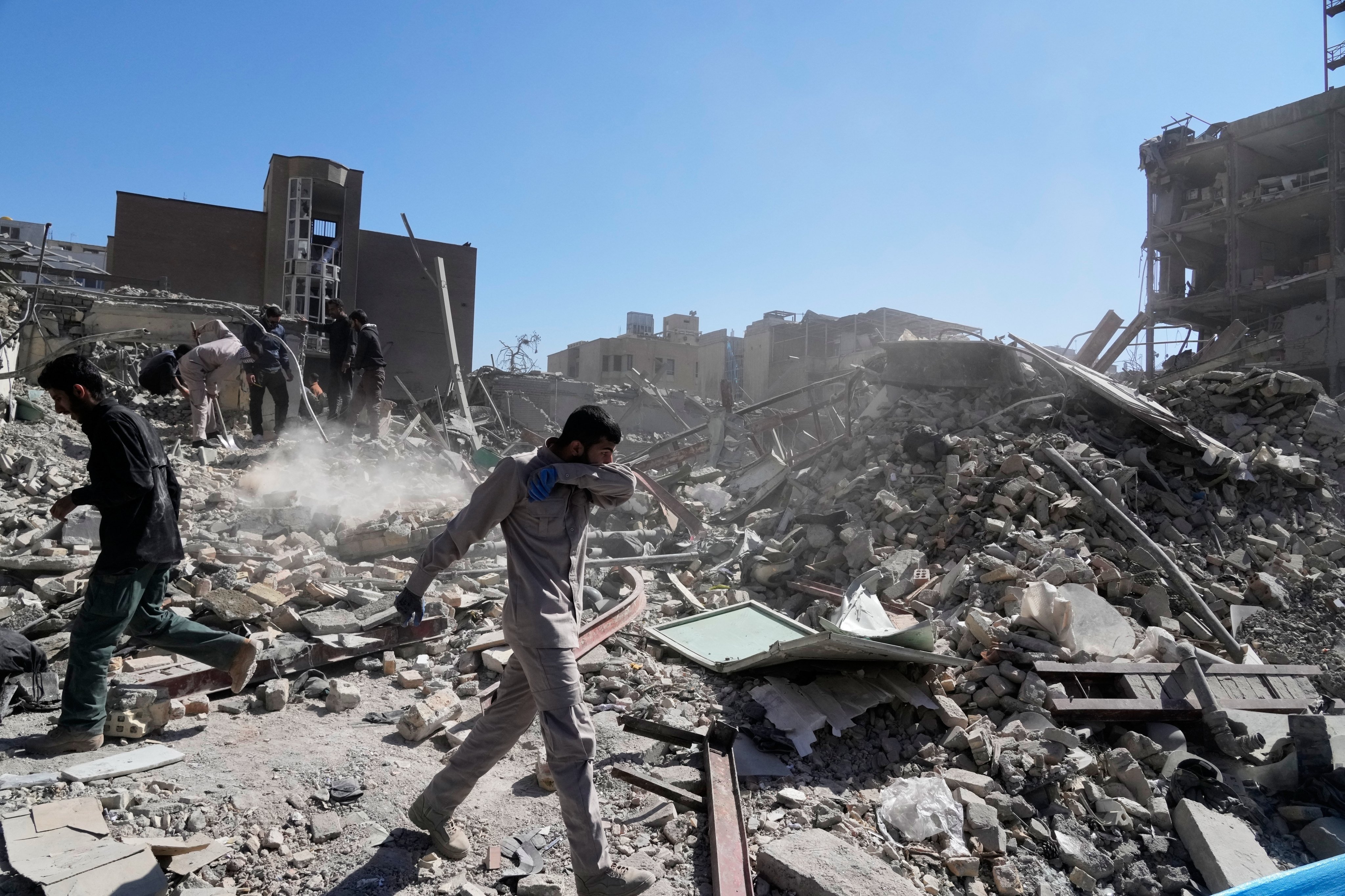 Men inspect the ruins of a police station on Tuesday in Tehran, Iran. Photo: AP
