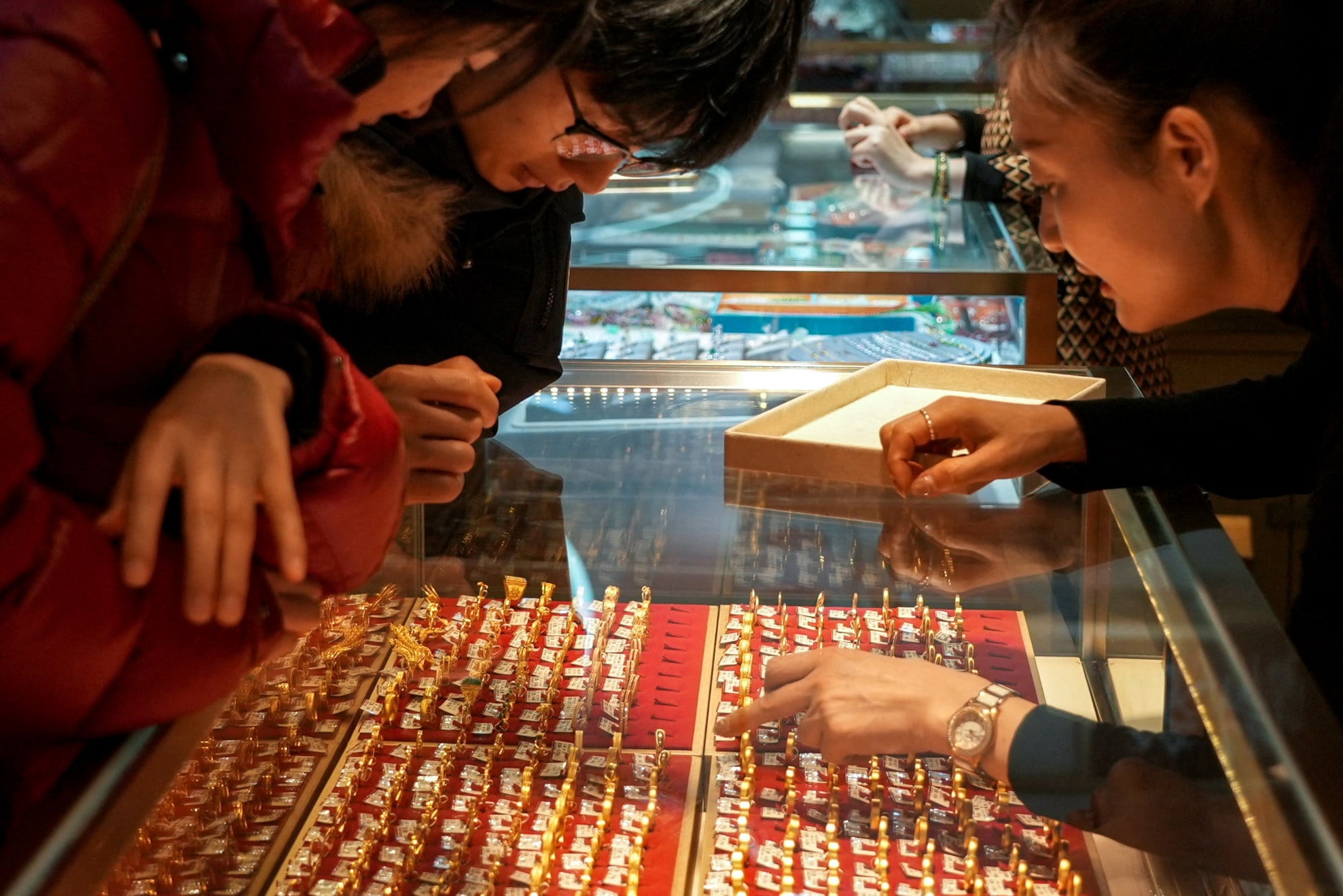 Customers look at gold rings in a Shanghai jewellery shop. In uncertain times the precious metal is increasingly being seen as a secure asset. Photo: Reuters
