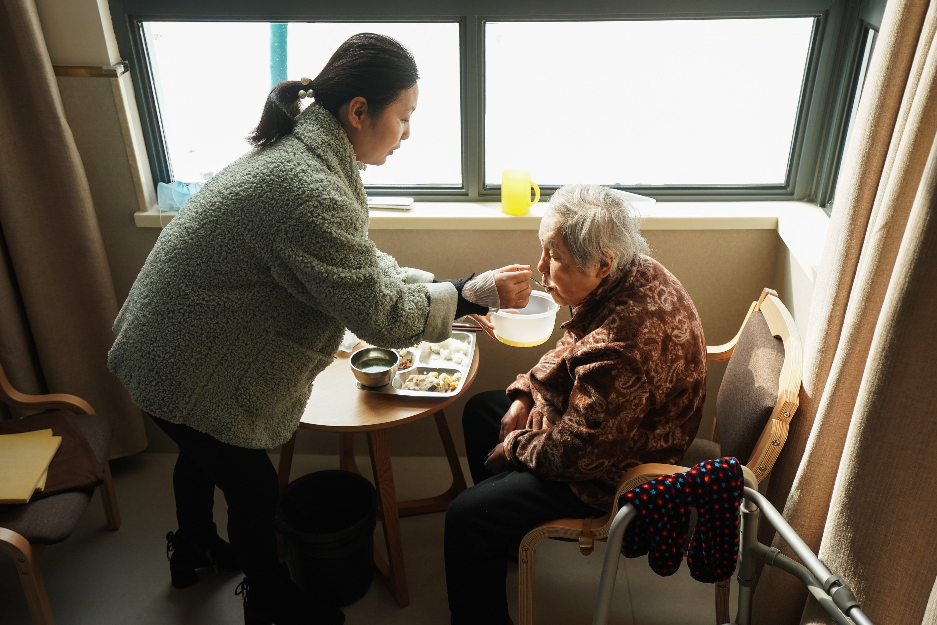 A daughter feeds her mother at a community elderly care centre in Suzhou, Jiangsu province in 2020. As families grow smaller in China, different generations face different decisions on elderly care. Photo: Xinhua