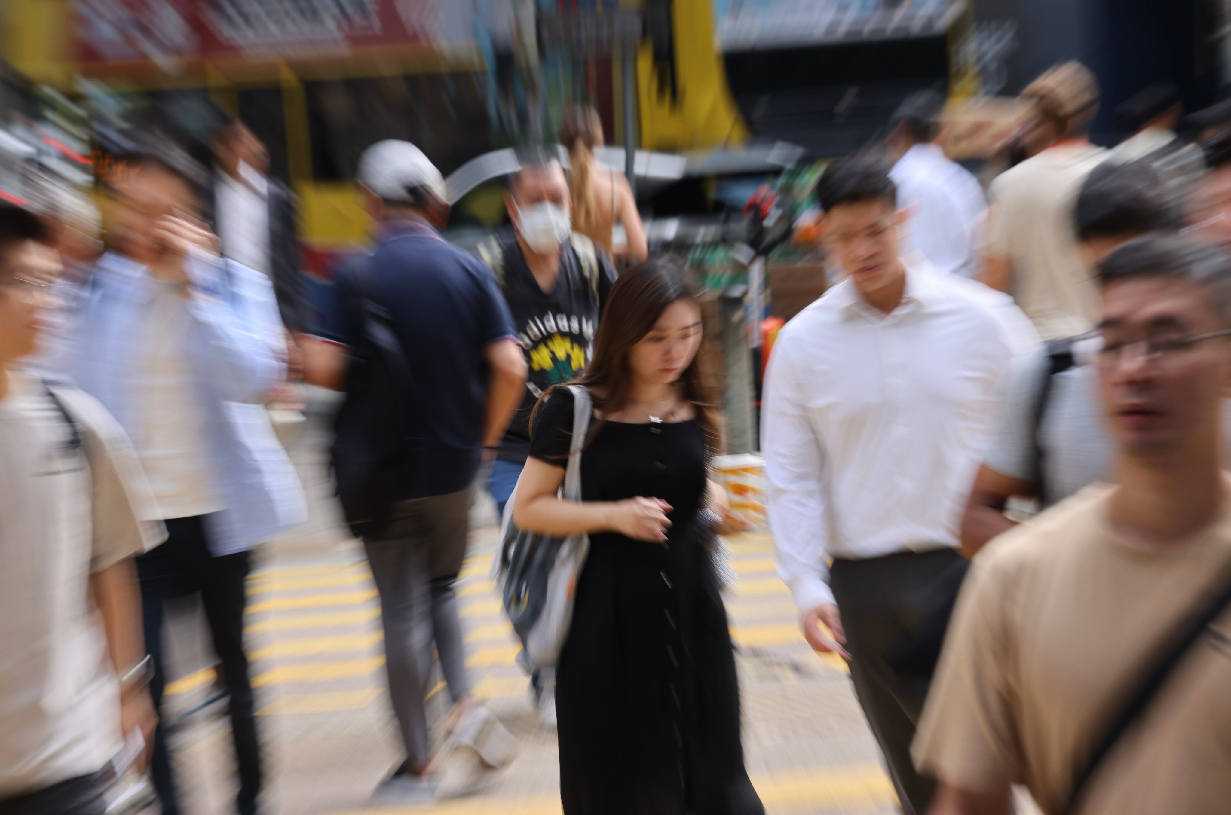 People cross a road in Central district in 2025. As society embraces AI, we need to ensure its development and adoption in business do not come at the expense of Hong Kong’s mental wellness. Photo: Karma Lo