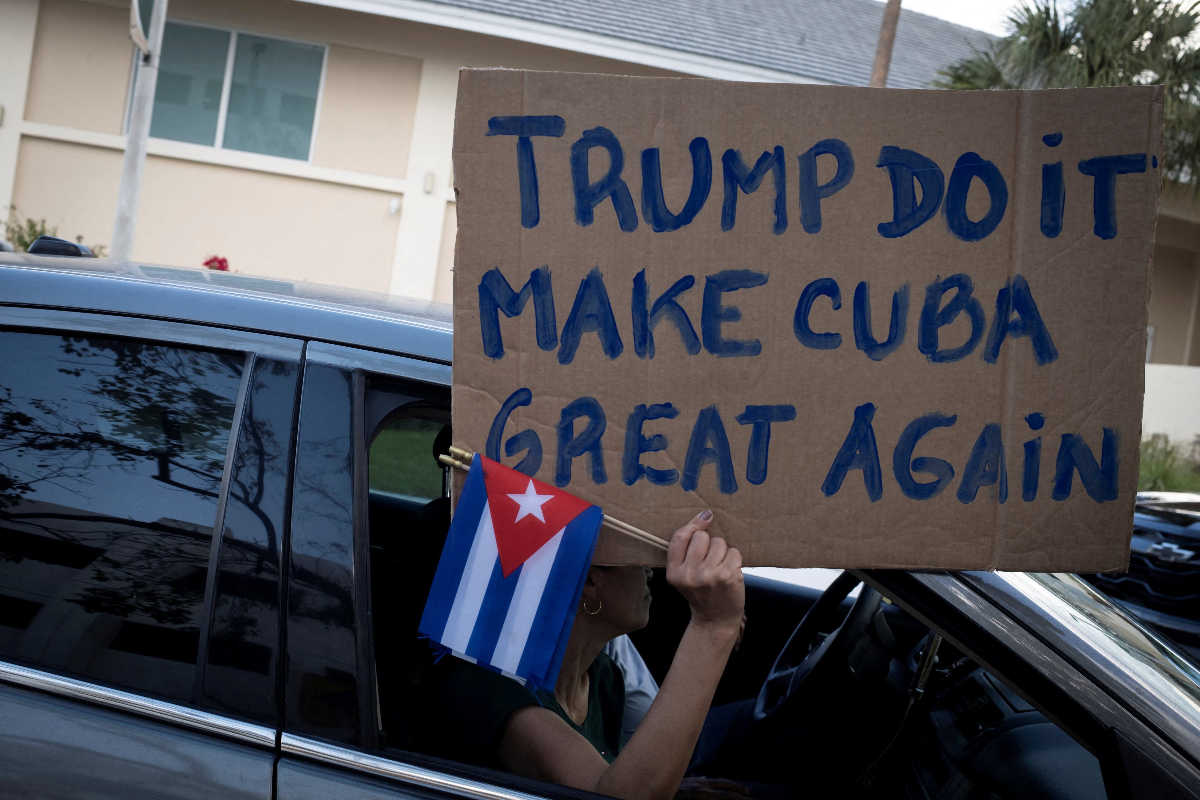 A woman holds a pro-Trump sign and Cuban flags during a protest against Cuba’s government in Miami, Florida, in February. Photo: Reuters