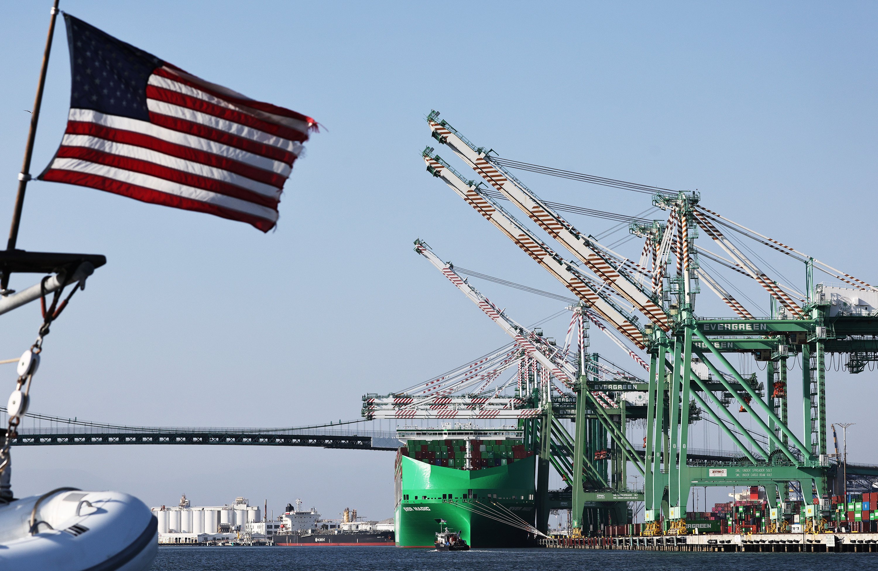 A US flies in front of shipping containers at the Port o Los Angeles in June 2025. Photo: TNS