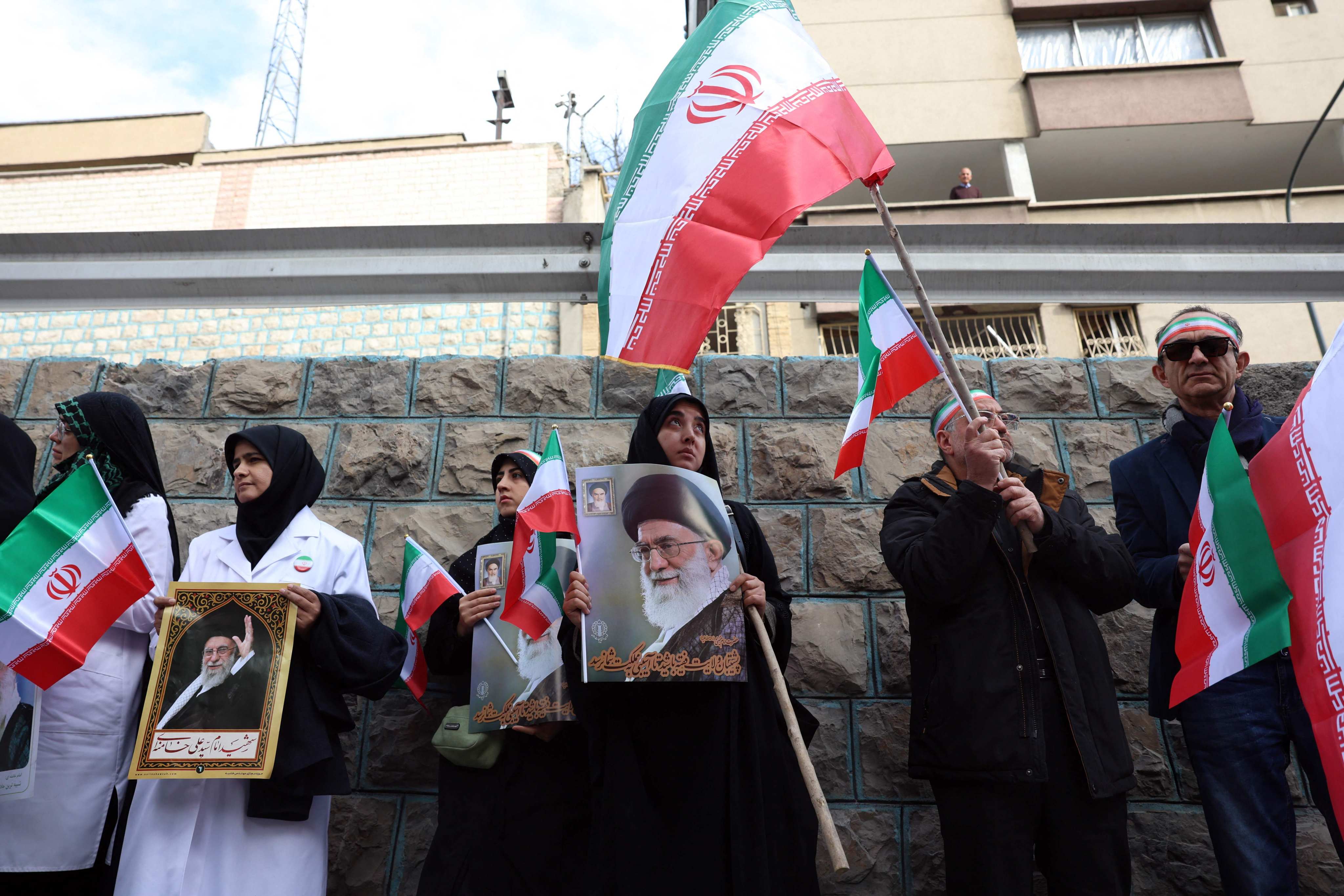 Iranian medical staff hold posters of slain Iranian supreme leader Ayatollah Ali Khamenei in front of the destroyed Gandhi Hospital in Tehran on Saturday. Photo: AFP