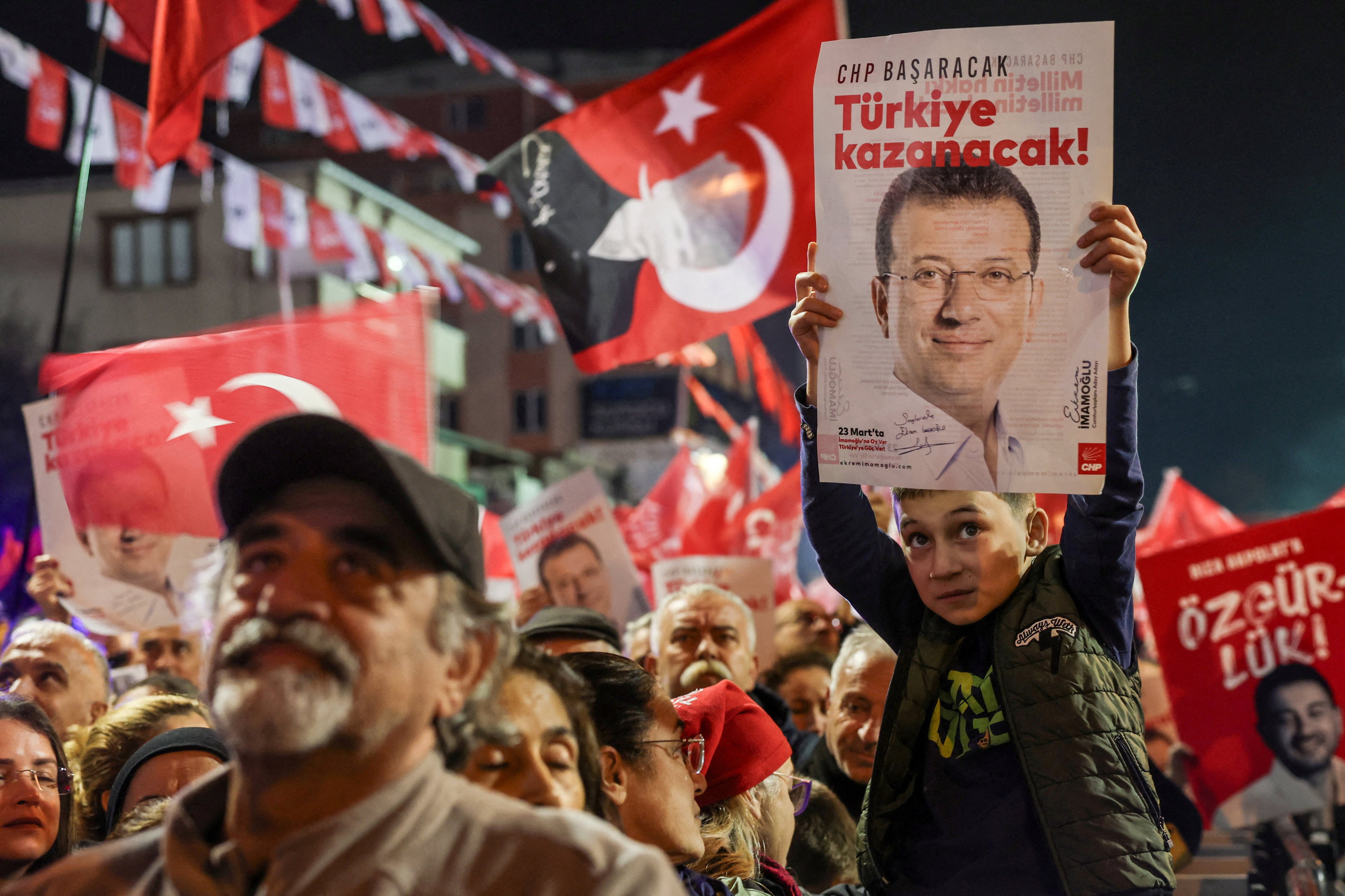 A supporter of Turkey’s main opposition CHP holds a poster of jailed Istanbul mayor Ekrem Imamoglu with a slogan reading “CHP will succeed, Turkey will win!”, during a rally in Istanbul in November 2025. Photo: Reuters