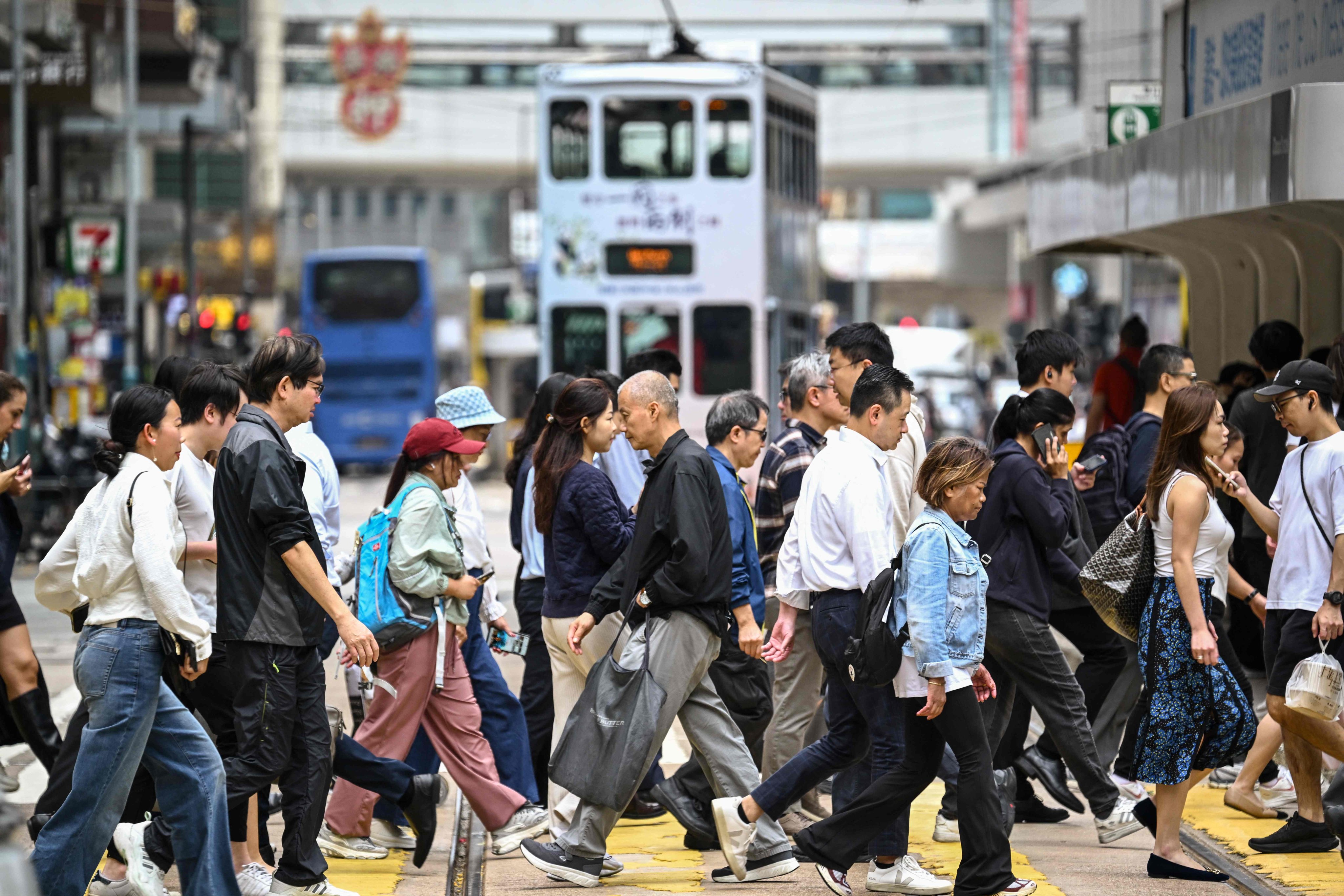Pedestrians cross a busy intersection in Hong Kong’s Central district on February 25. Photo: AFP
