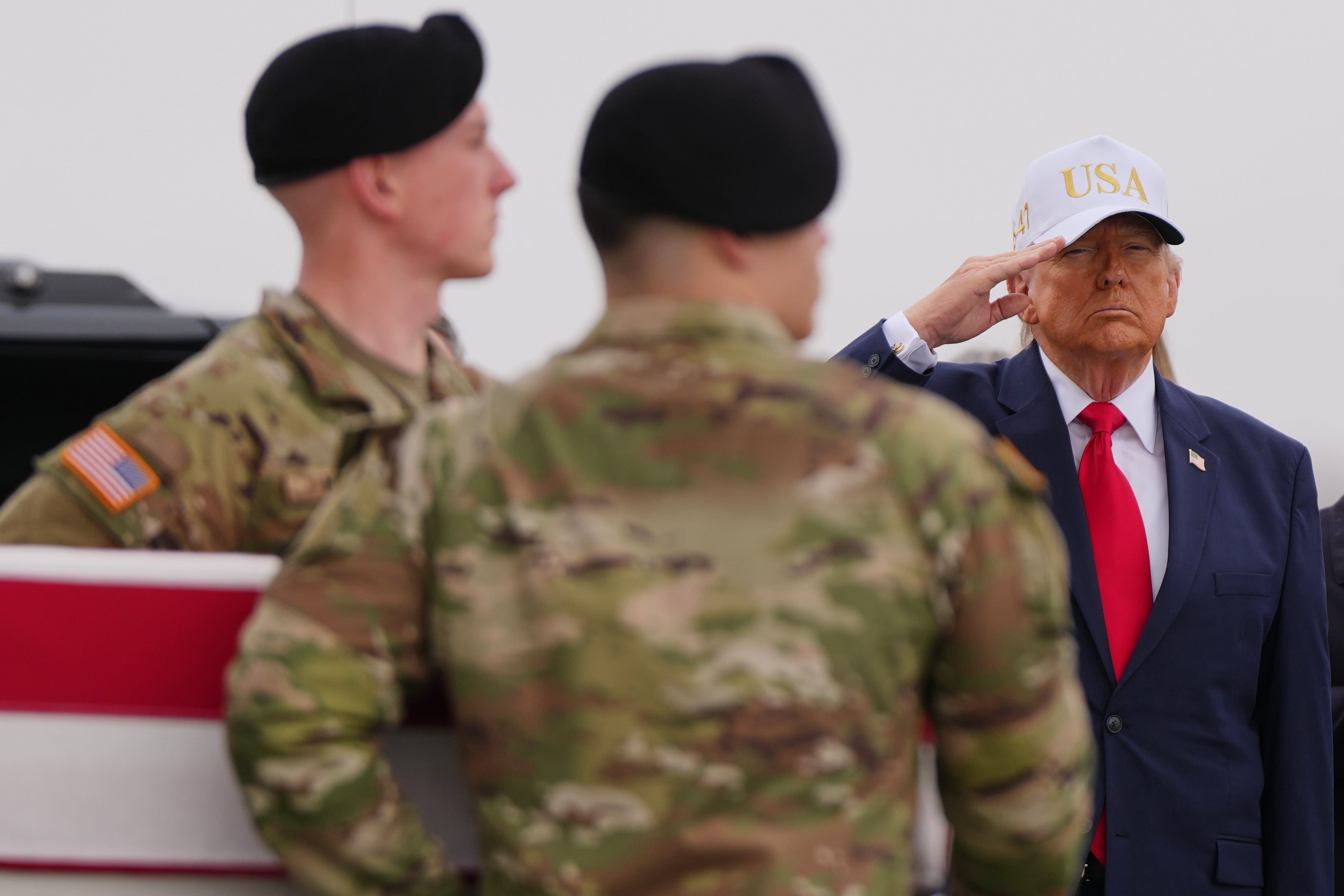 US President Donald Trump salutes at Dover Air Force Base in Delaware on Saturday as an Army carry team moves the flag-draped transfer case containing the remains of one of the US soldiers killed in Kuwait. Photo: AP