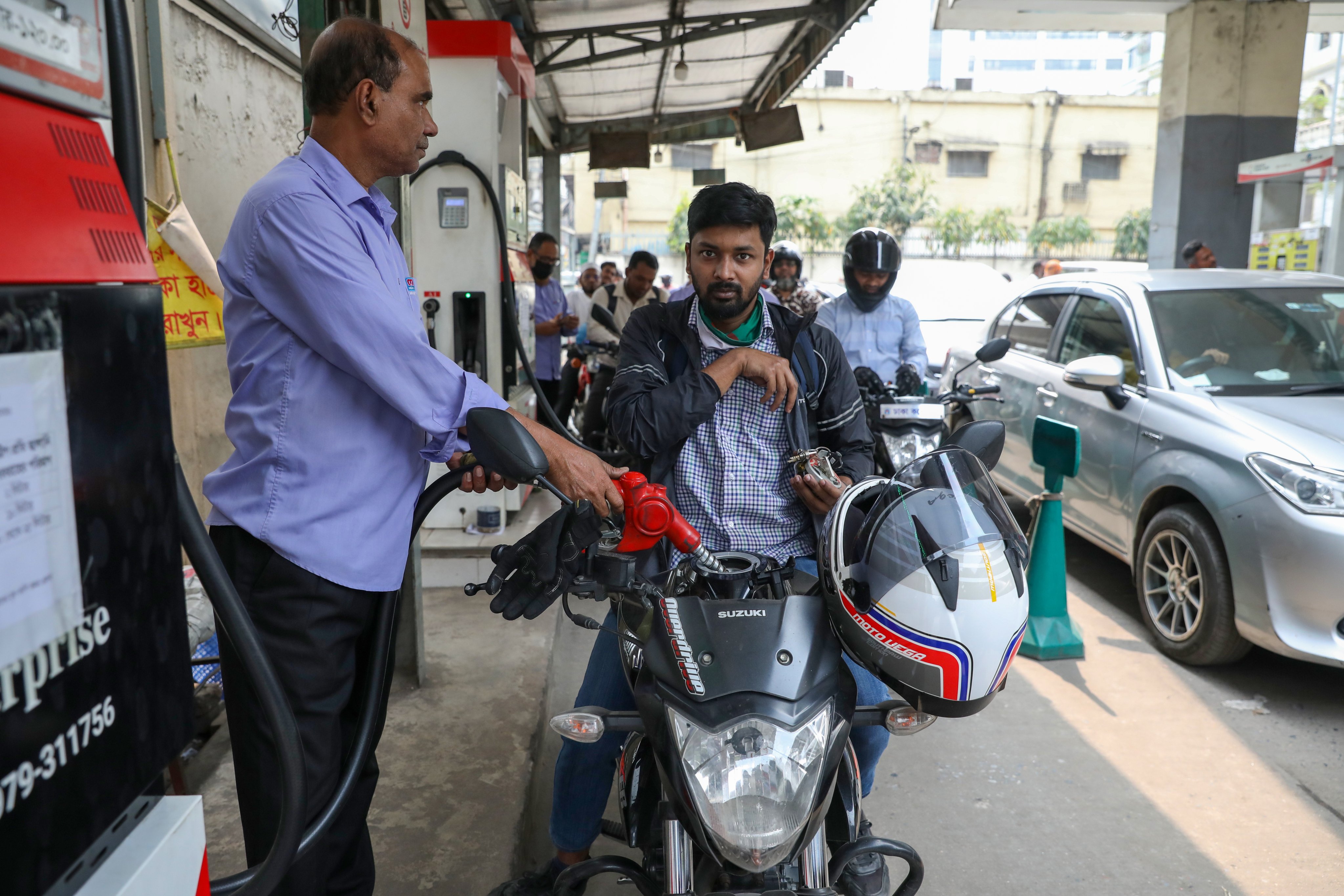 A man refuels his motorcycle at a fuel station in Dhaka, Bangladesh, on Sunday. Photo: EPA-EFE