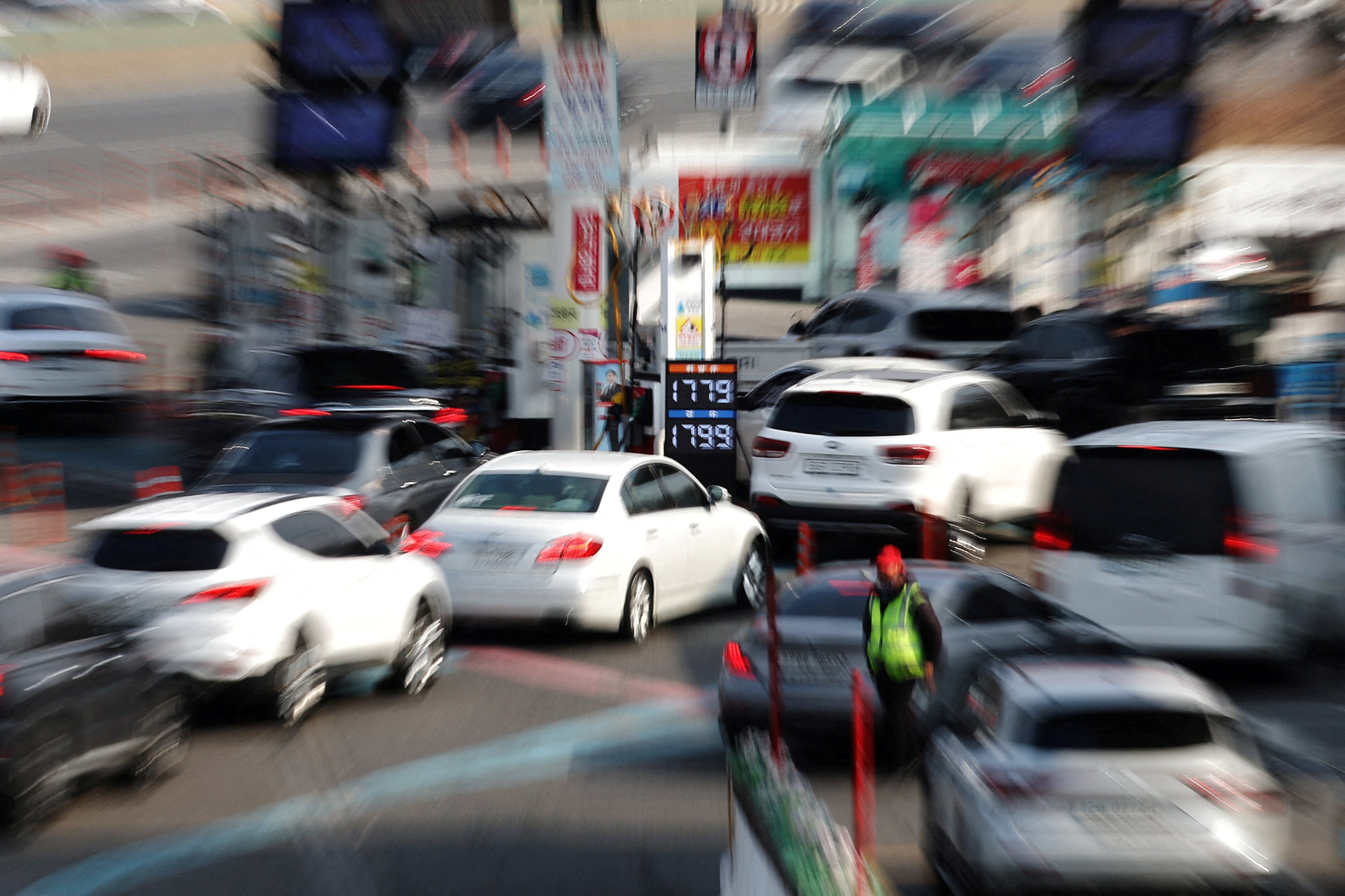 A board shows prices as cars queue at a petrol station in Seoul, South Korea, on Monday. Photo: Reuters