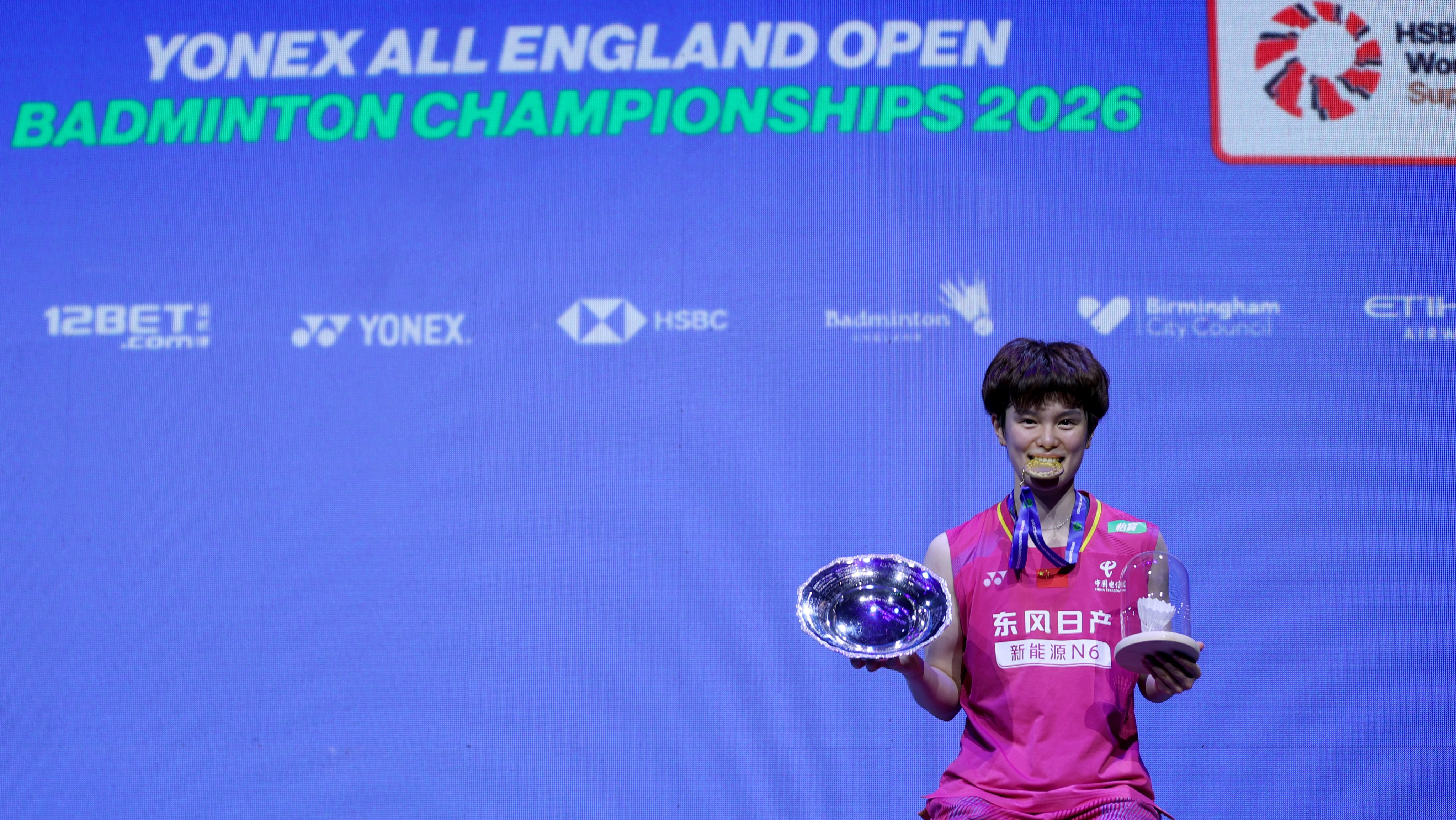Wang Zhiyi poses with her medal and trophy after winning the women’s singles at the All England Open Badminton Championships. Photo: Xinhua