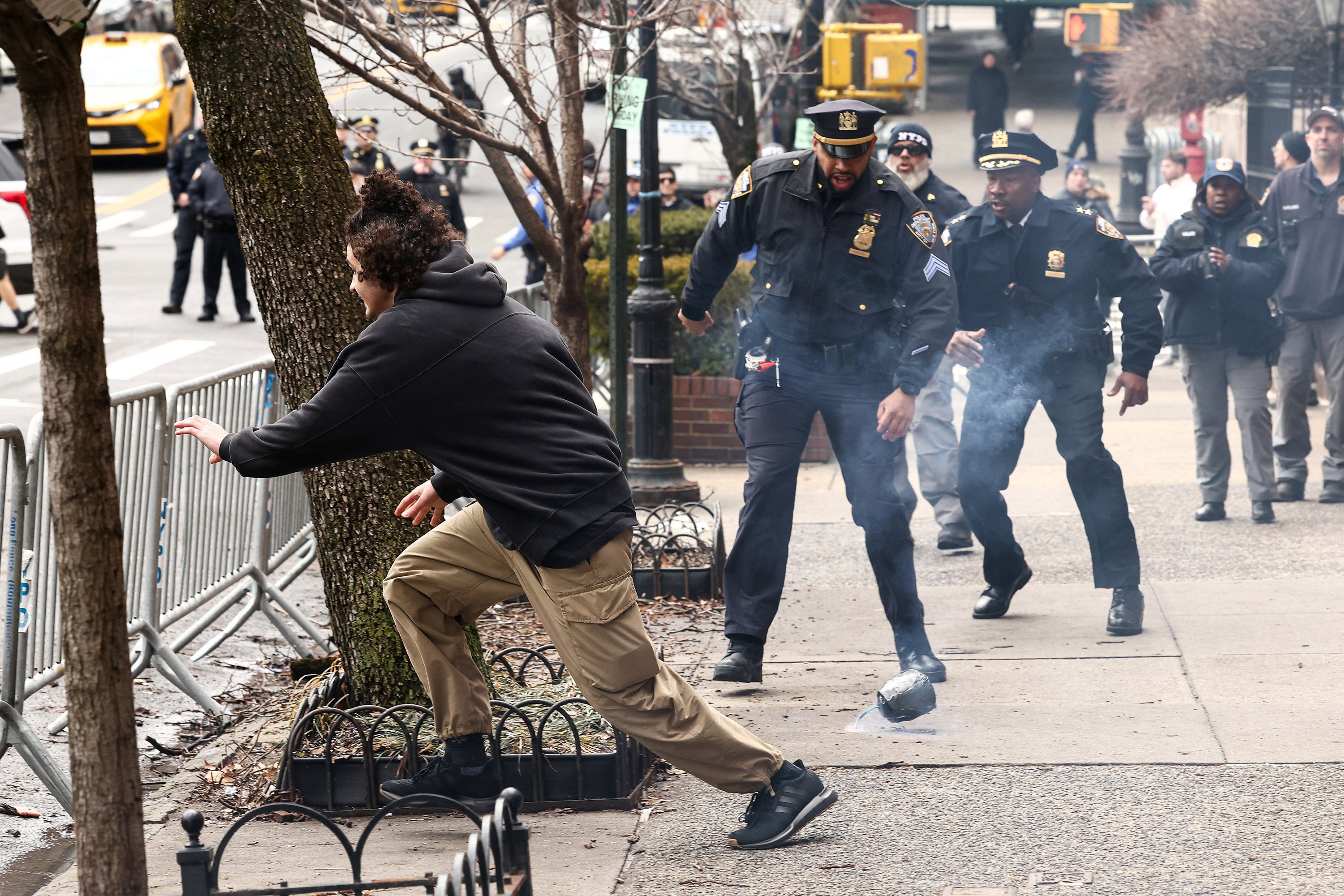 A man flees after throwing a home-made explosive device towards police in New York on Saturday. Photo: AFP