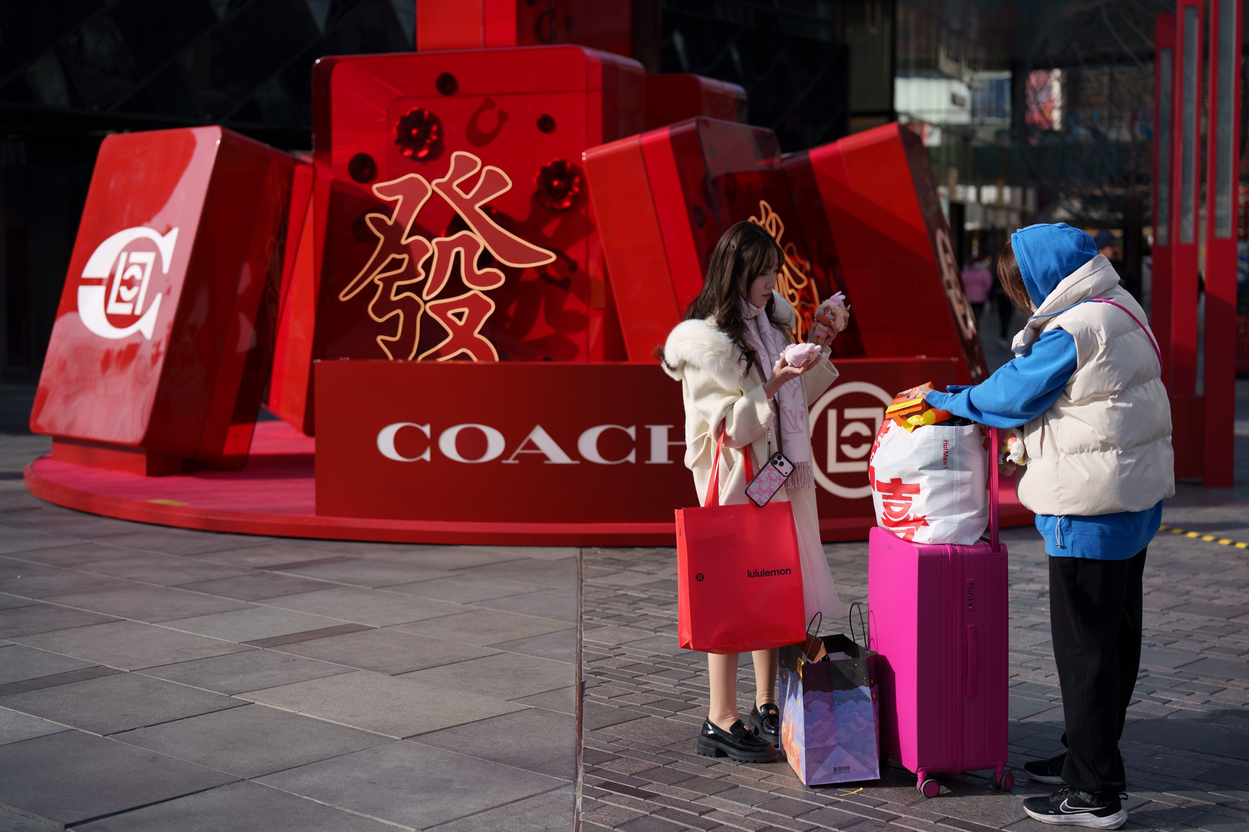 Shoppers stand near a Chinese New Year display in central Beijing. Photo: AP