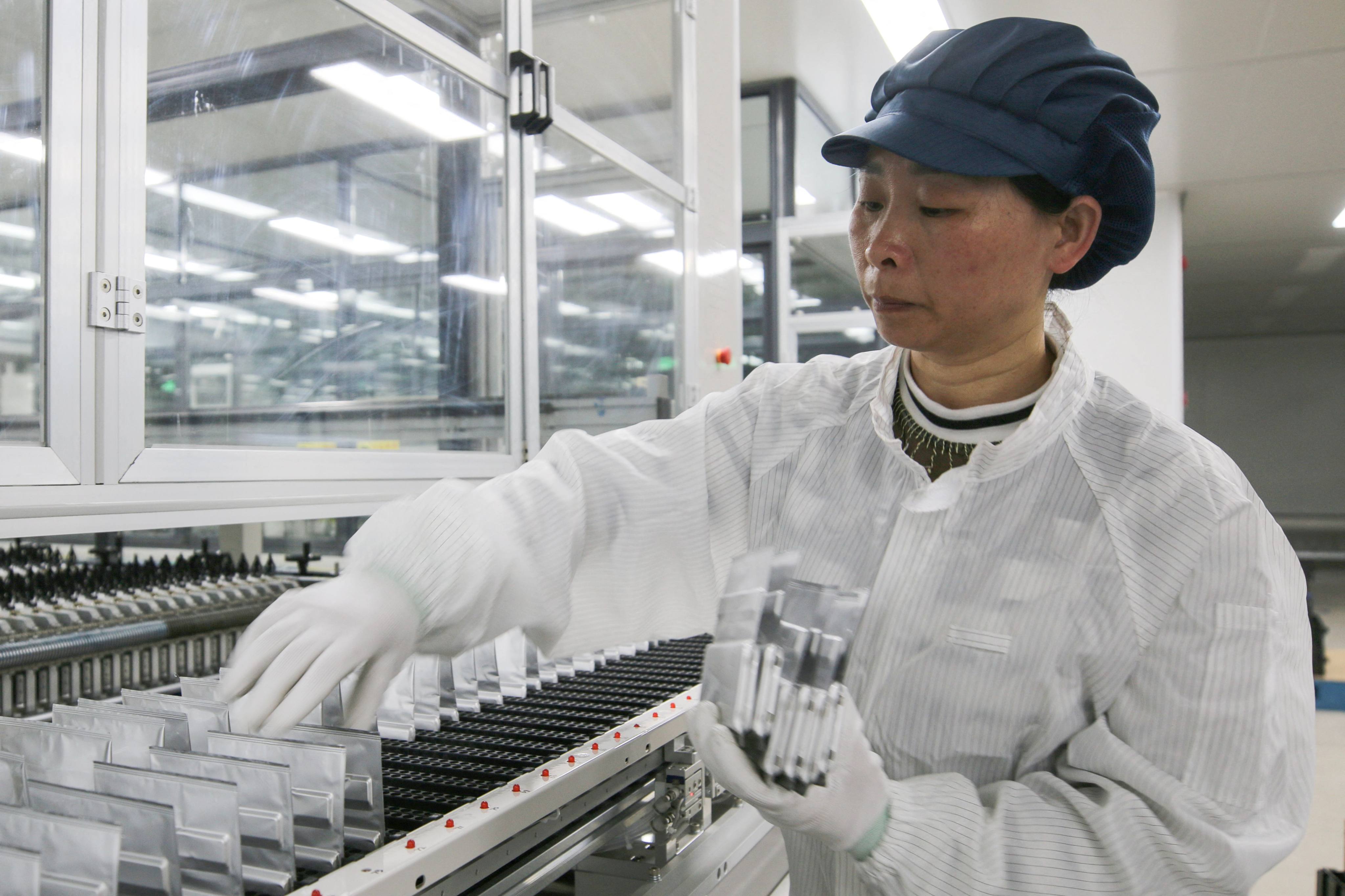 A woman works on lithium batteries at Yunqi Lithium Energy’s factory in Suichuan county, in China’s eastern Jiangxi province. Photo: AFP