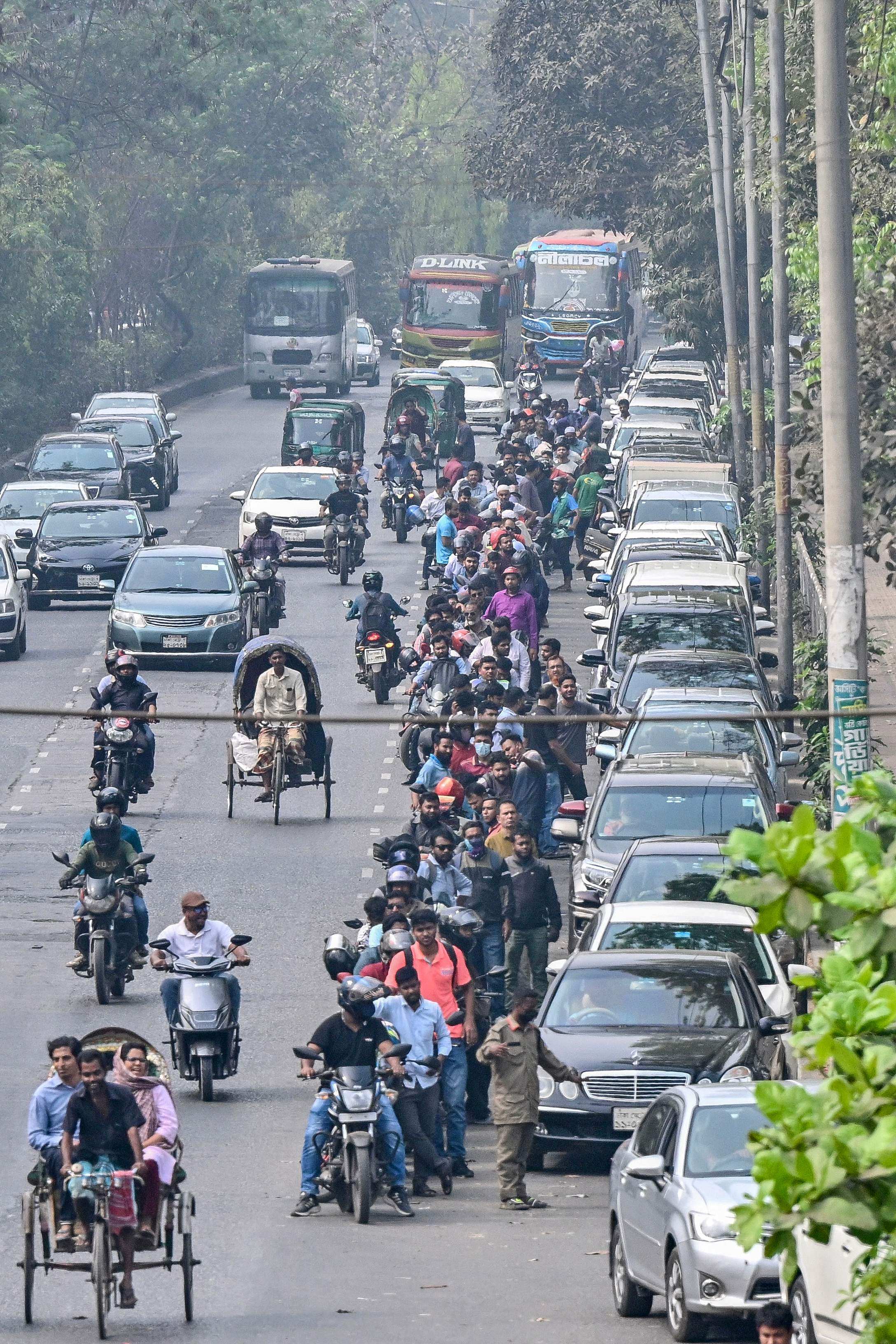 People wait to refuel their vehicles near a fuel station in Dhaka on Monday. Bangladesh launched fuel rationing on Sunday. Photo: AFP