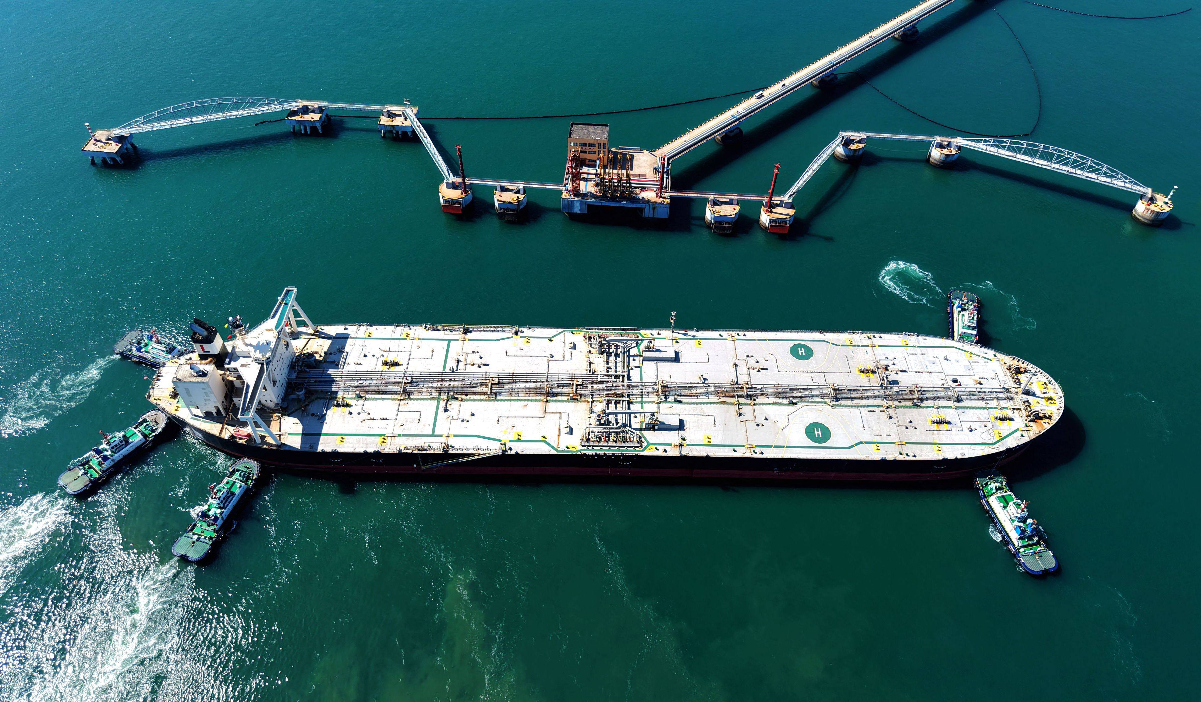 A crude oil tanker is guided to a berth at a terminal in China’s Shandong province on Saturday. Photo: AFP