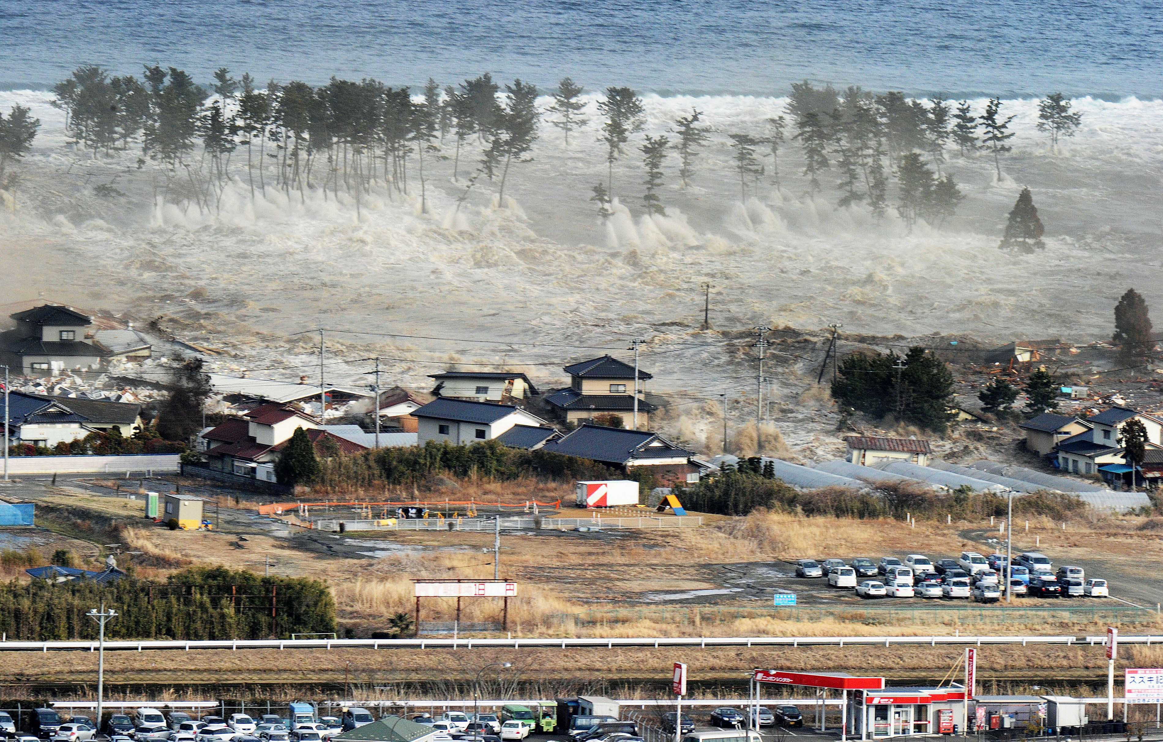 Tsunami waves hit residences after a powerful earthquake in Natori, Miyagi prefecture, Japan, on March 11, 2011. Photo: AP Photo