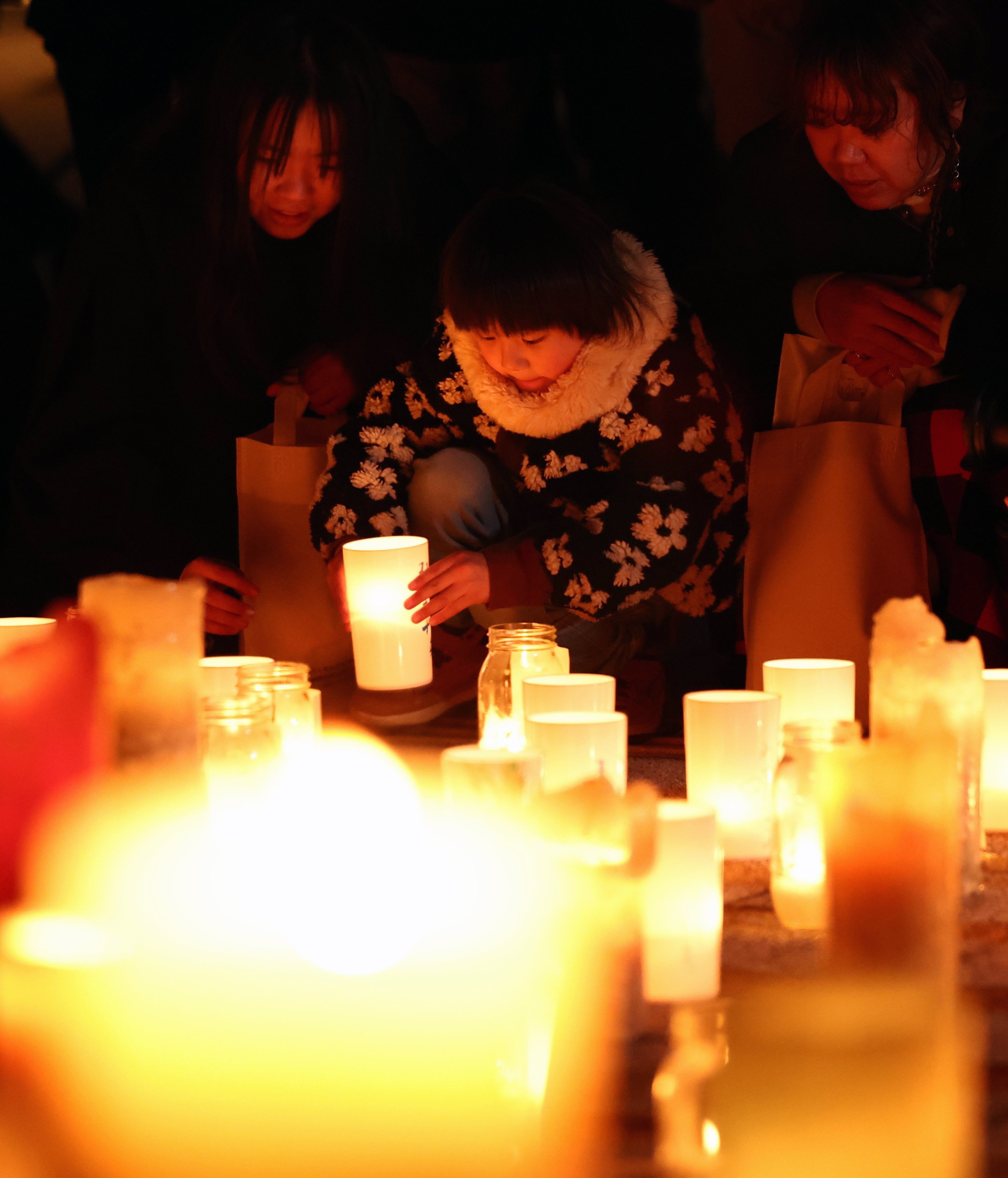 People offer prayers and light candles during a memorial in front of Futaba Station on Tuesday ahead of the 15th anniversary of the Fukushima earthquake and tsunami.  Photo: Jiji Press/EPA
