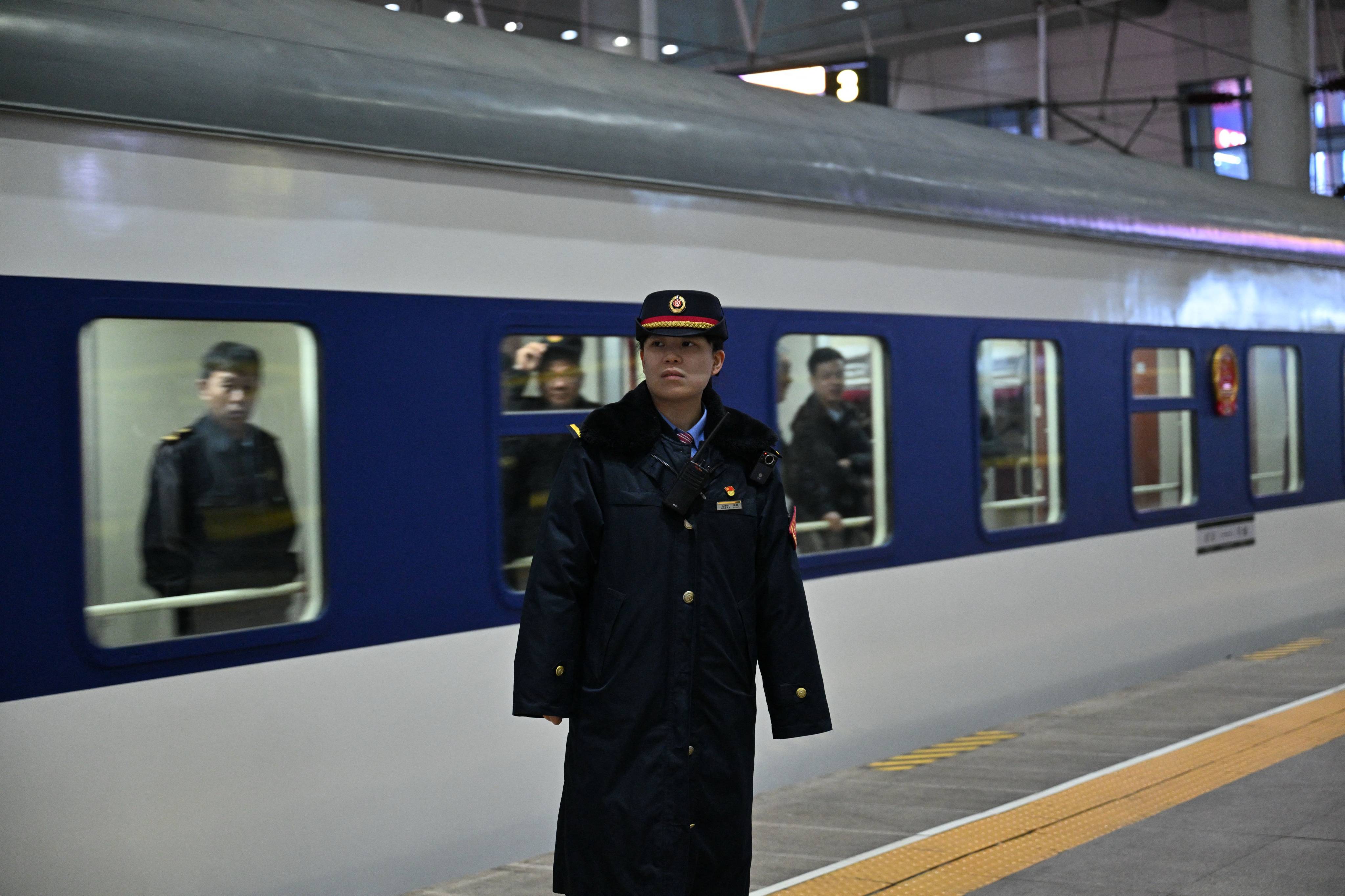 An official stands in front of the K27 train bound to Pyongyang, at the Tianjin station in Tianjin on March 12, 2026. A passenger train that departed from the northeastern Chinese city of Dandong arrived in the North Korean capital Pyongyang on March 12, as rail service between the neighbouring countries resumed after six years. (Photo by ADEK BERRY / AFP)