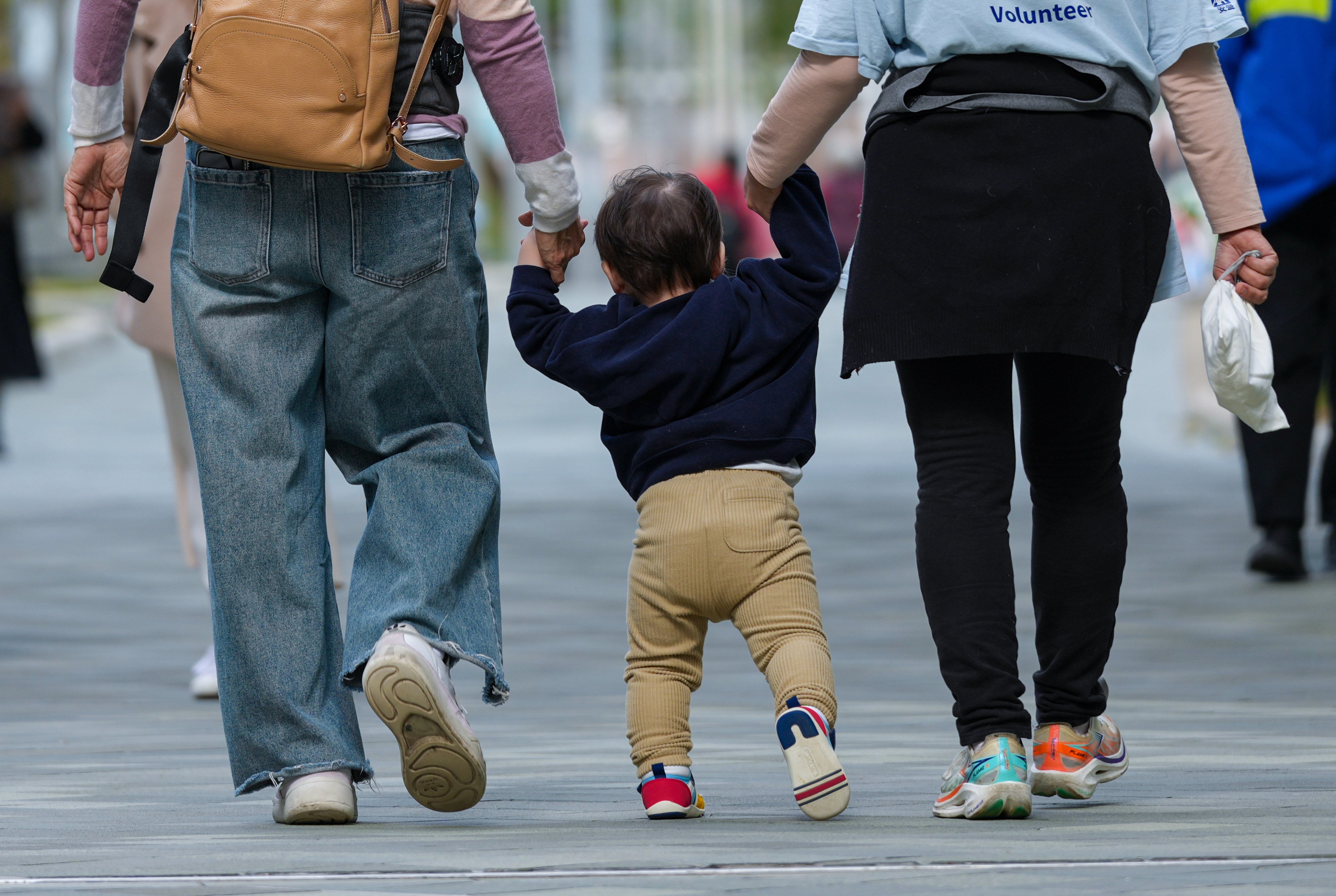 A child holds hands with adults in Admiralty on January 20, as the Mandatory Reporting of Child Abuse Ordinance came into effect. Photo: Jelly Tse