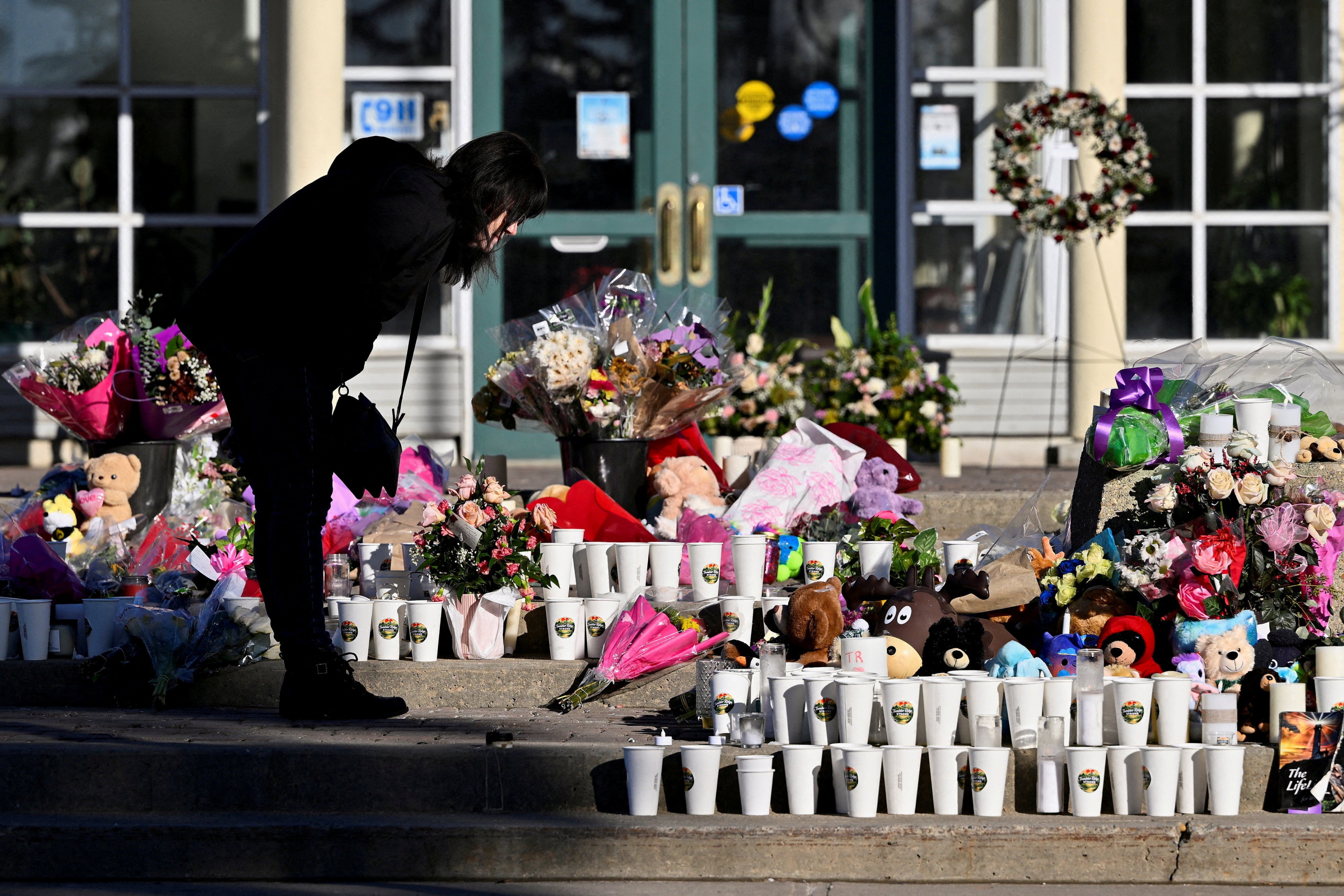 A woman visits a makeshift memorial to shooting victims in Tumbler Ridge, British Columbia, Canada, in February. Photo: Reuters