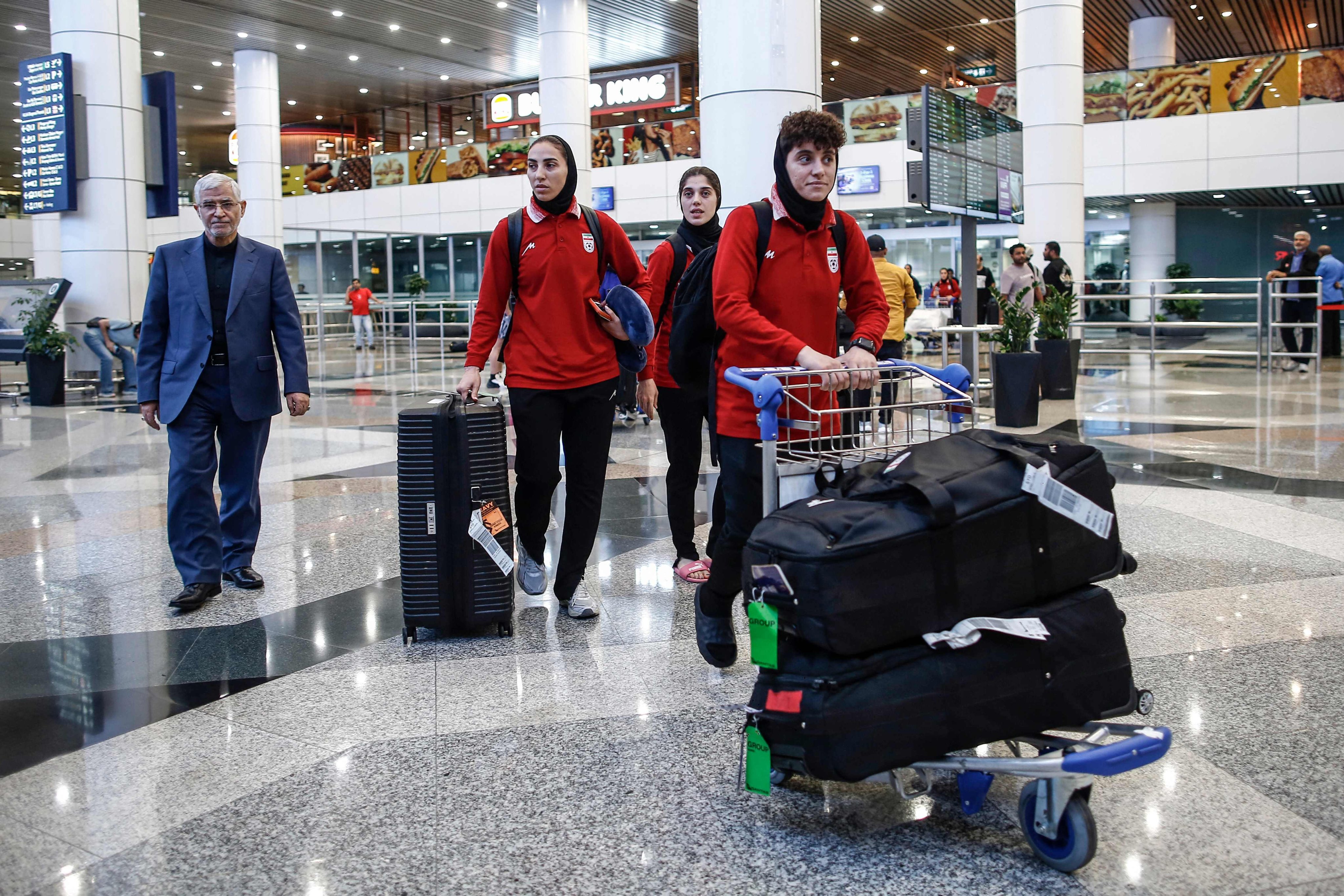 Members of Iran’s women’s football team walk with their luggage as they arrive at Kuala Lumpur International Airport on Wednesday. Photo: AFP