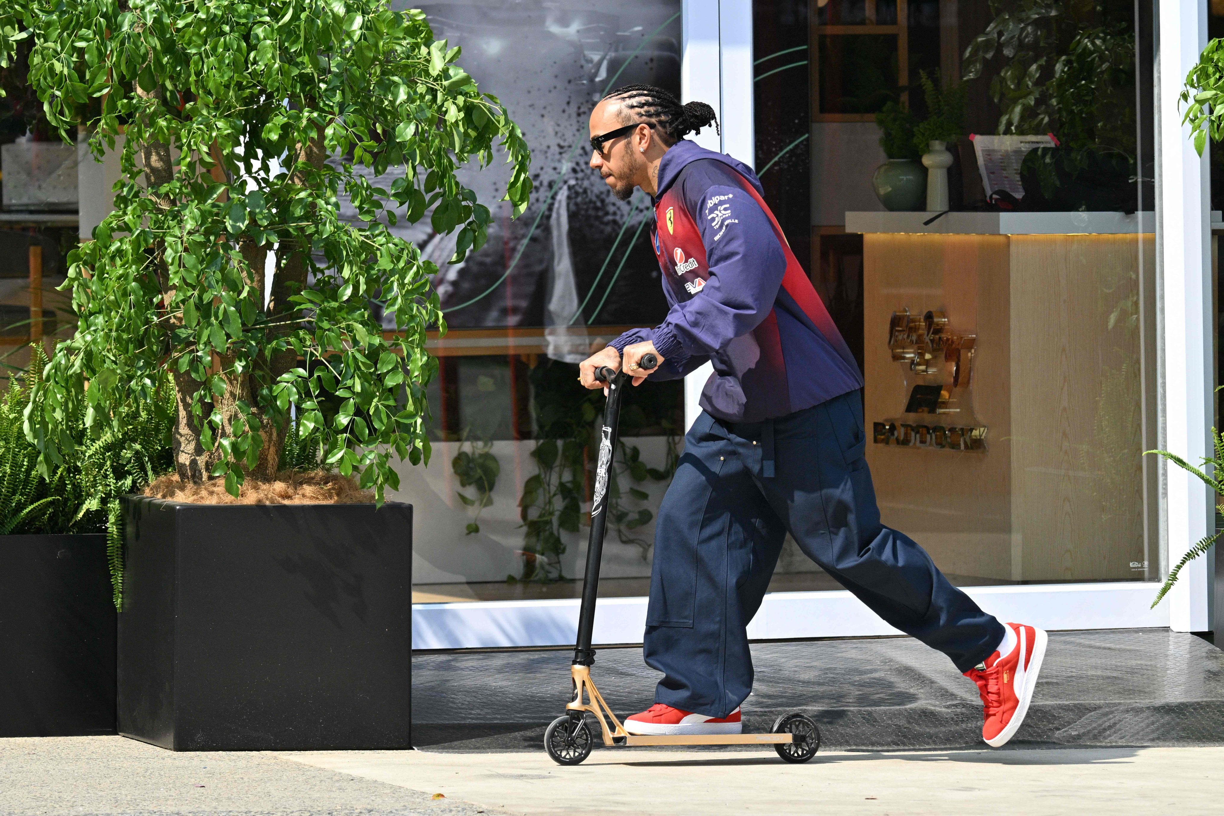 Ferrari’s British driver Lewis Hamilton rides a scooter in the paddock on Thursday at the Shanghai International Circuit ahead of the F1 Chinese Grand Prix this weekend. Photo: AFP