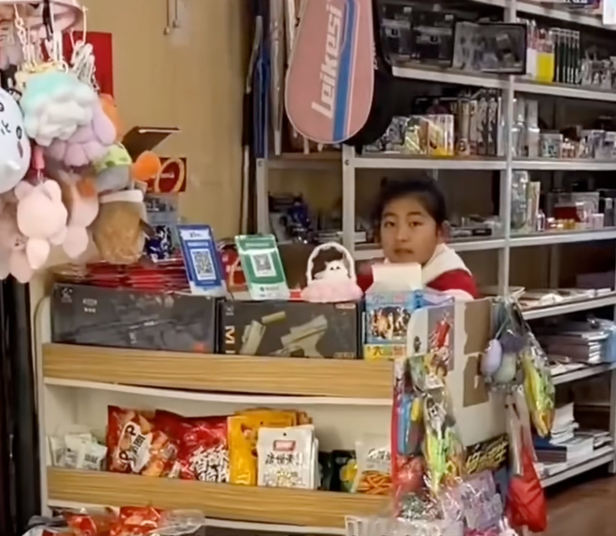Li pictured sitting behind the payment counter of her well-stocked shop. Photo: YouTube