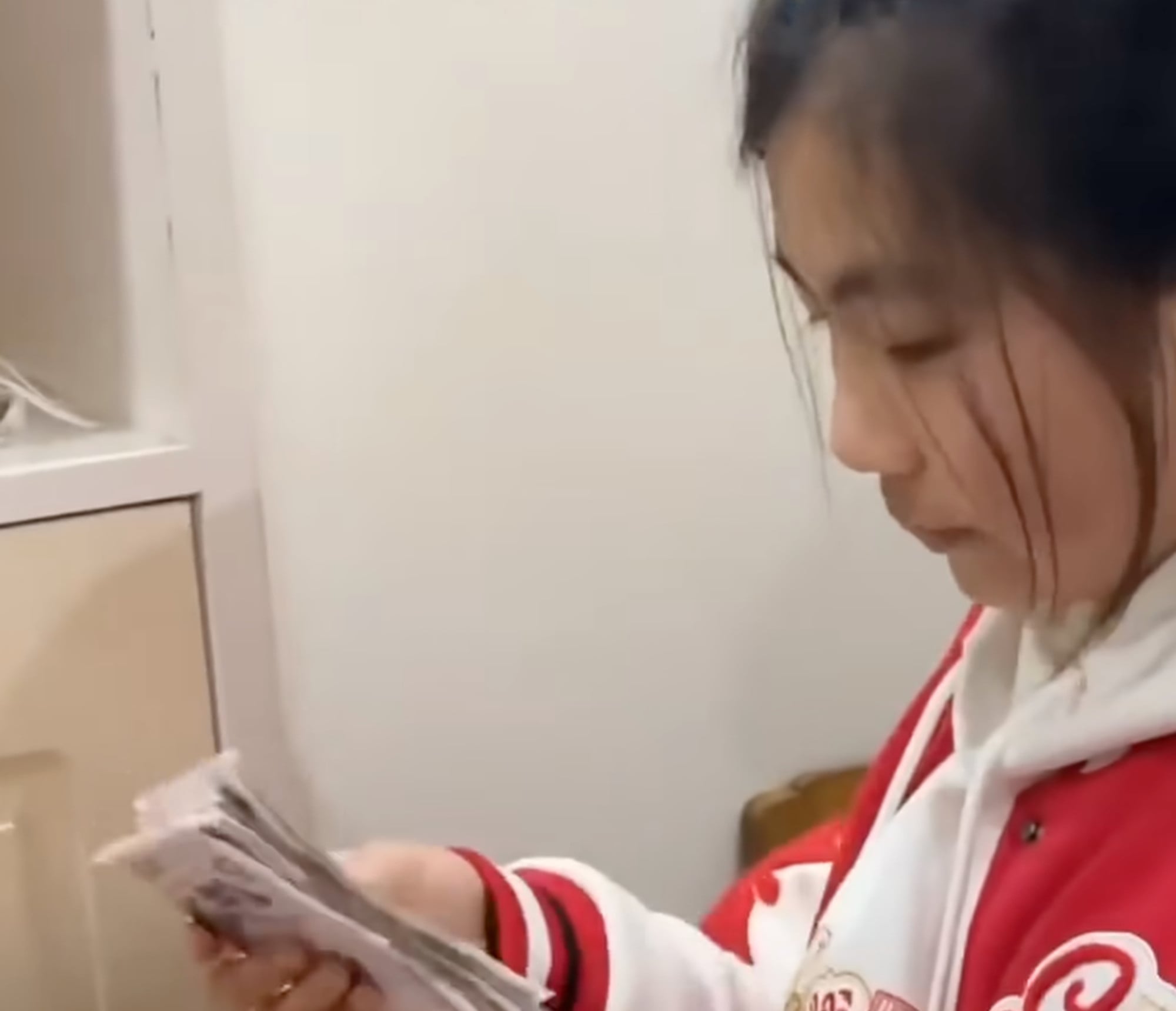 Cash in hand: Li gets down to the serious business of counting the day’s takings. Photo: YouTube