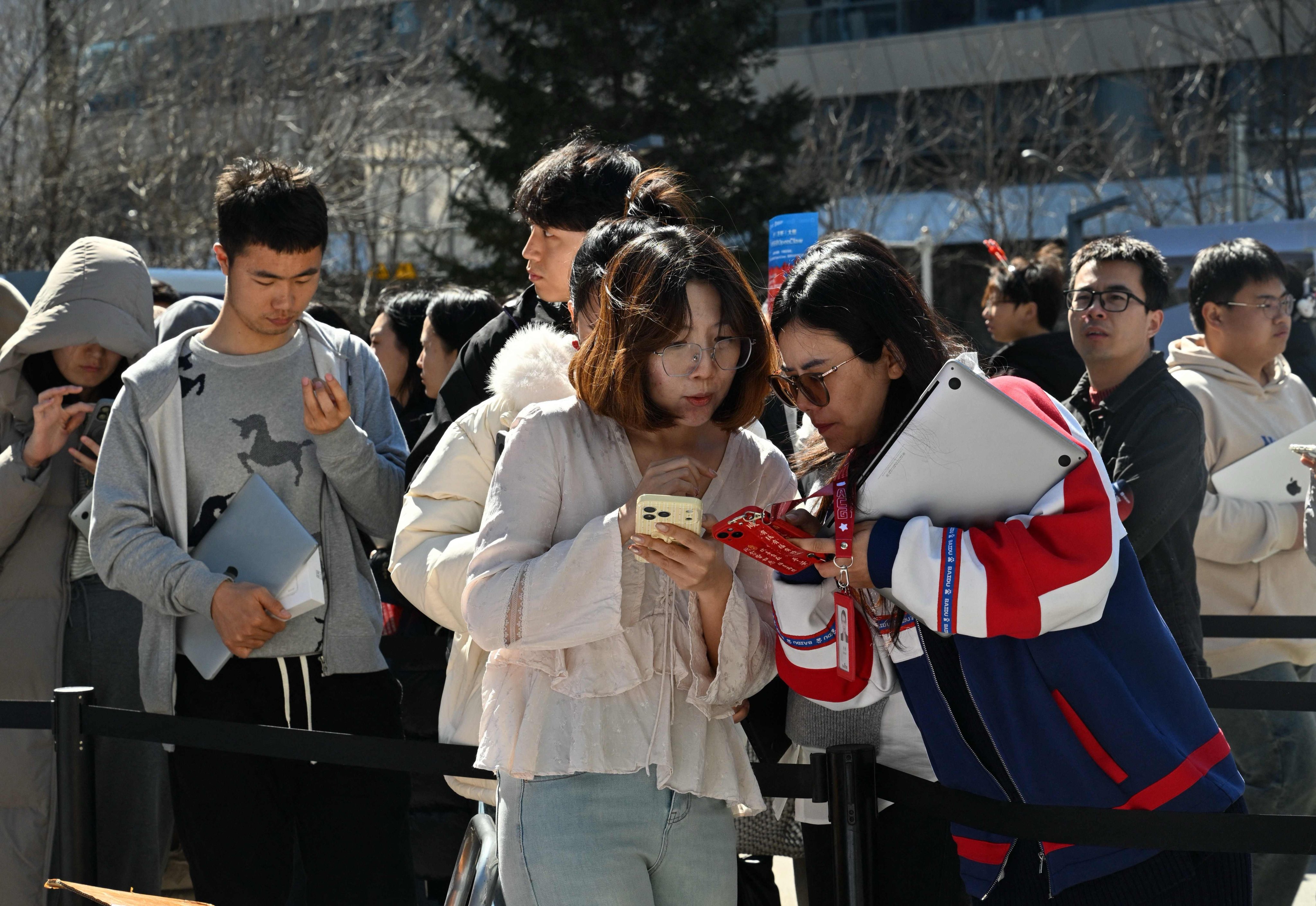 Members of the public queue to have their laptops installed with OpenClaw, an open-source AI assistant, in Beijing on March 11. Photo: AFP