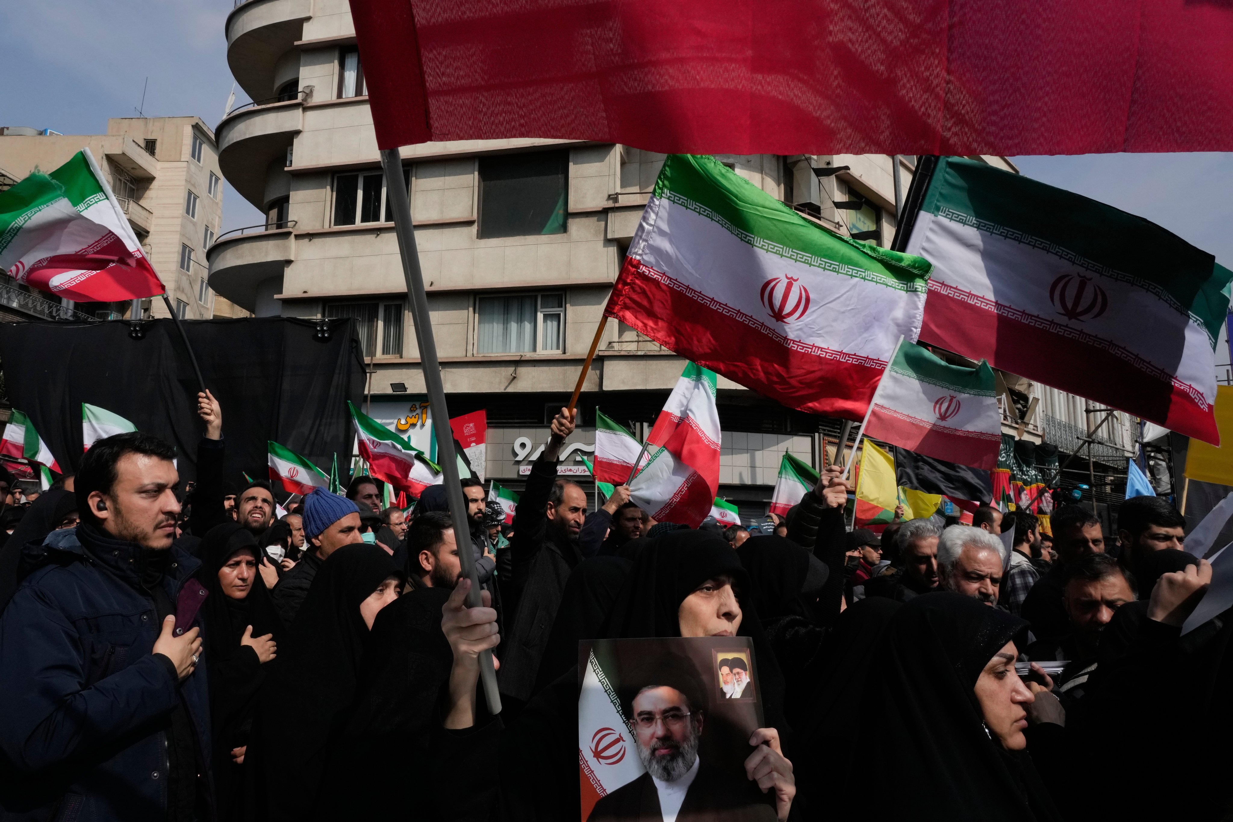 Mourners wave Iranian flags during the funeral procession for senior military officials and civilians killed during the US-Israel campaign in Tehran on Wednesday. Photo: AP