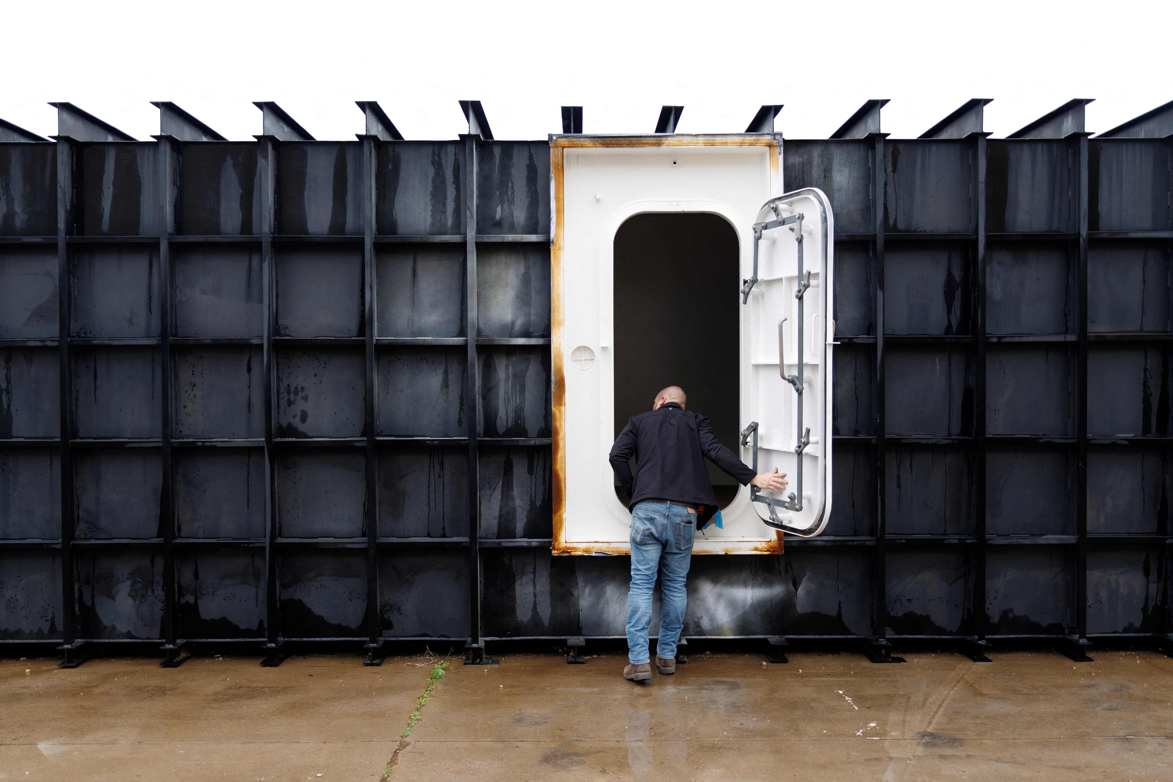 Shop manager Davis Yarber opens up a survival shelter door at the Atlas Survival Shelters factory. Photo: AFP