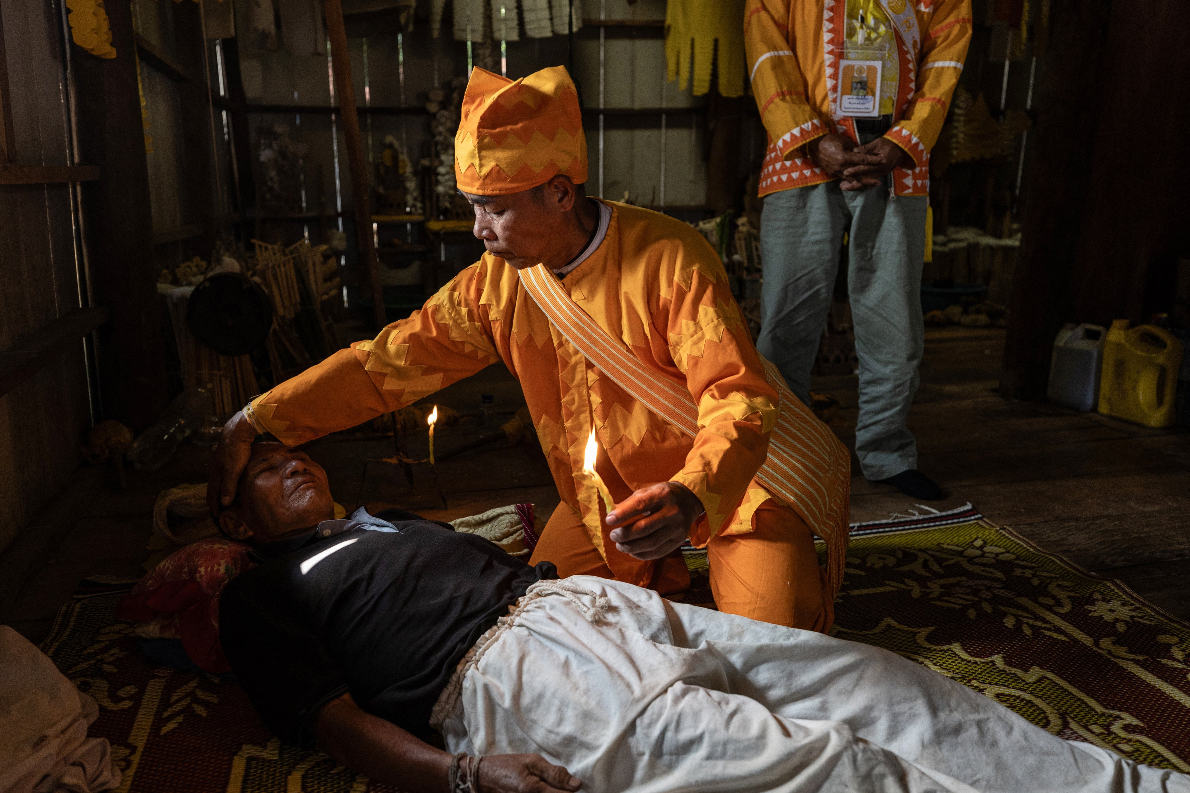 This handout courtesy of Luke Duggleby taken on December 10, 2025 and released to AFP on February 25, 2026 shows Lahu elder and religious leader Jaha Satae (C) undertaking a drug cleansing ceremony on Jawa Jabo (black shirt), 70, who has struggled with methamphetamine and opium addiction for many years, in the village of Mae Haeng in Chiang Mai’s Mae Ai district. Hundreds of thousands of people in northern Thailand have become collateral damage from the civil war in neighbouring Myanmar, turning to drugs as supply through the area rockets on the back of the conflict. (Photo by Luke Duggleby / Courtesy of Luke Duggleby / AFP) / RESTRICTED TO EDITORIAL USE - MANDATORY CREDIT “AFP PHOTO / LUKE DUGGLEBY / HANDOUT “ - NO MARKETING - NO ADVERTISING CAMPAIGNS - DISTRIBUTED AS A SERVICE TO CLIENTS

TO GO WITH ‘THAILAND-MYANMAR-CRIME-SOCIAL-LAHU,REPORTAGE’ BY NATHAPHOB SUNGKATE