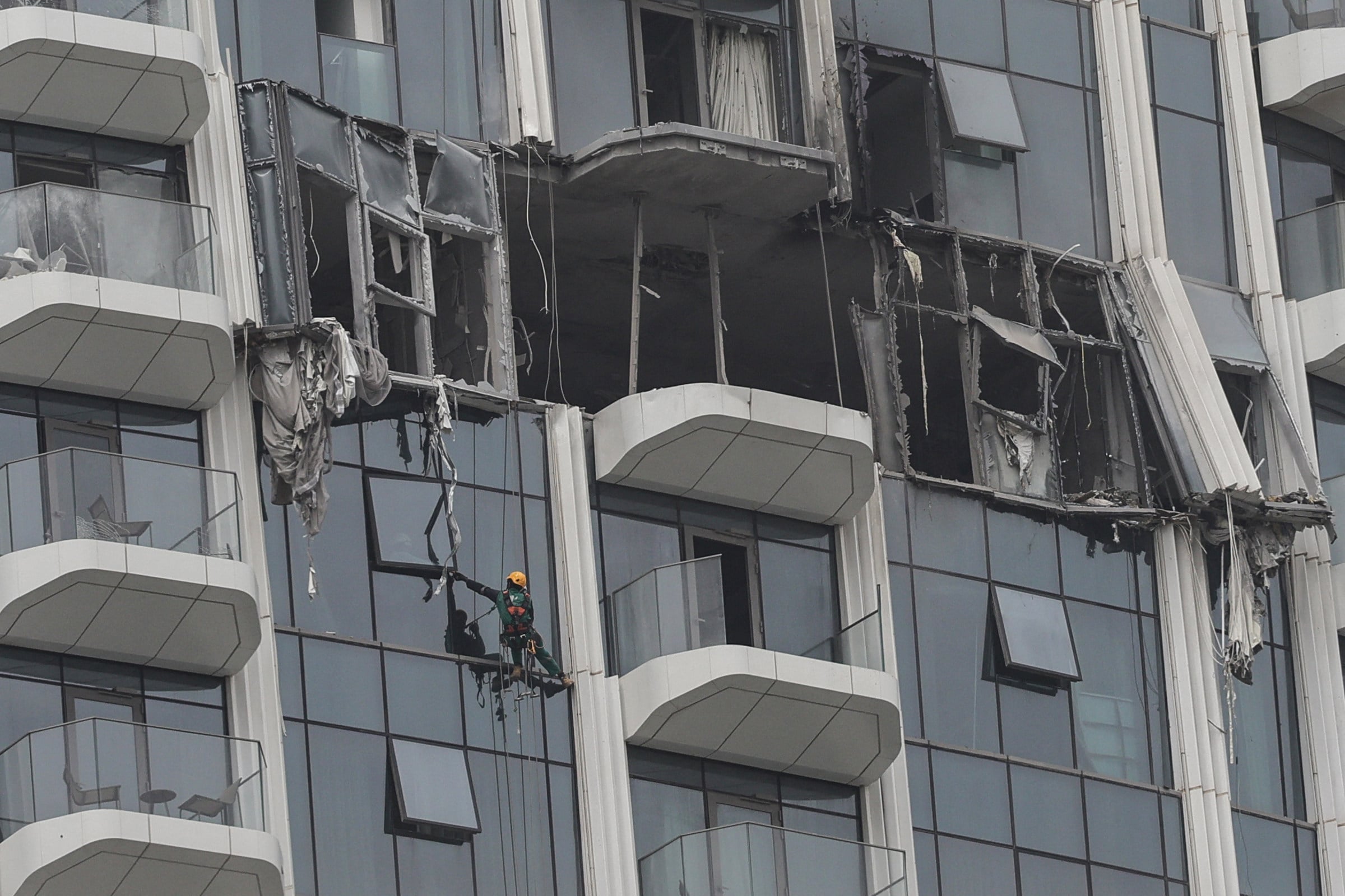 A worker assesses the damage after a drone strike on a building in Dubai’s Creek Harbour neighbourhood on Thursday. Photo: Getty Images/AFP